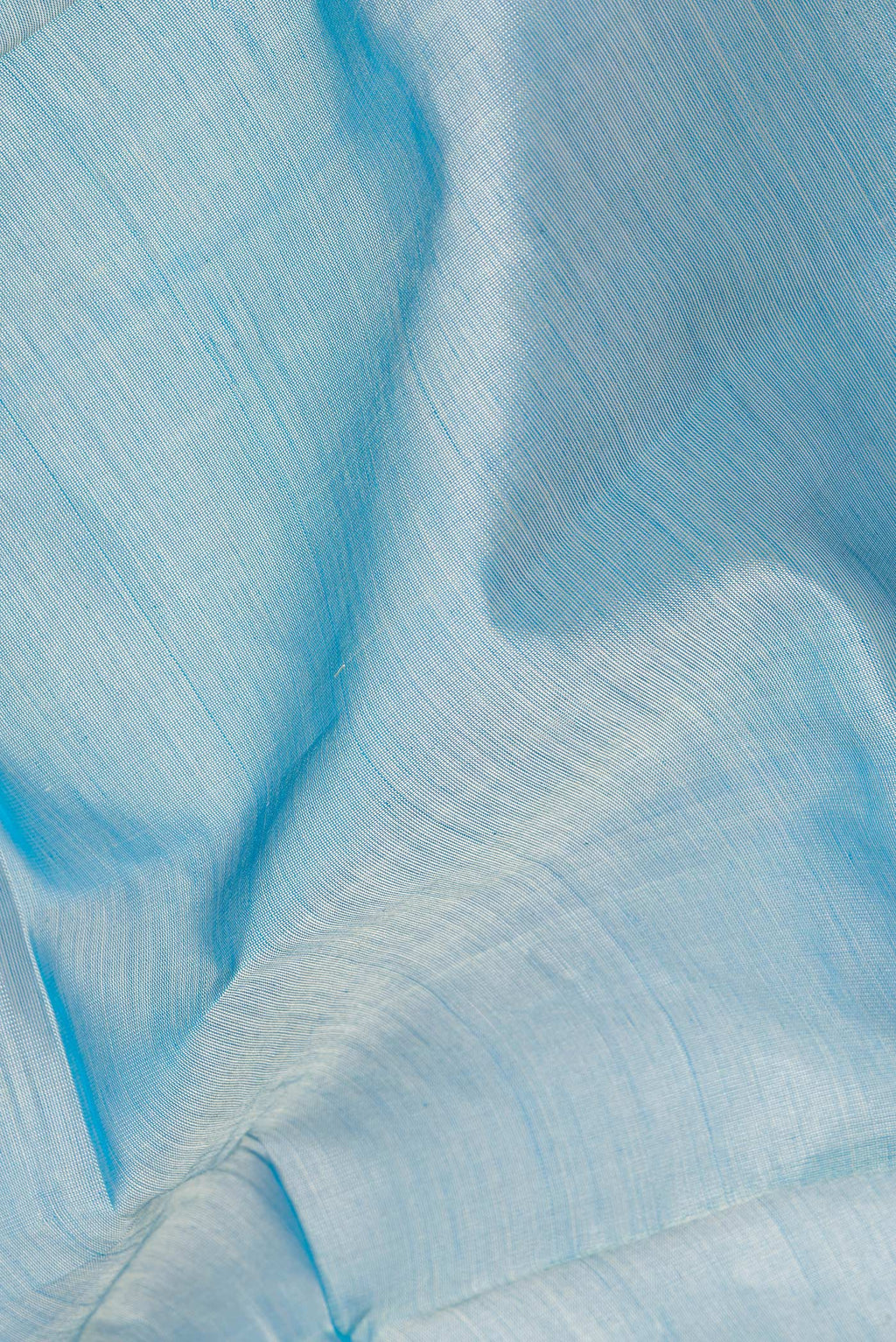 Close up of Light Blue Silk Cotton Saree with Plain Body and Zari Border.  displaying folds