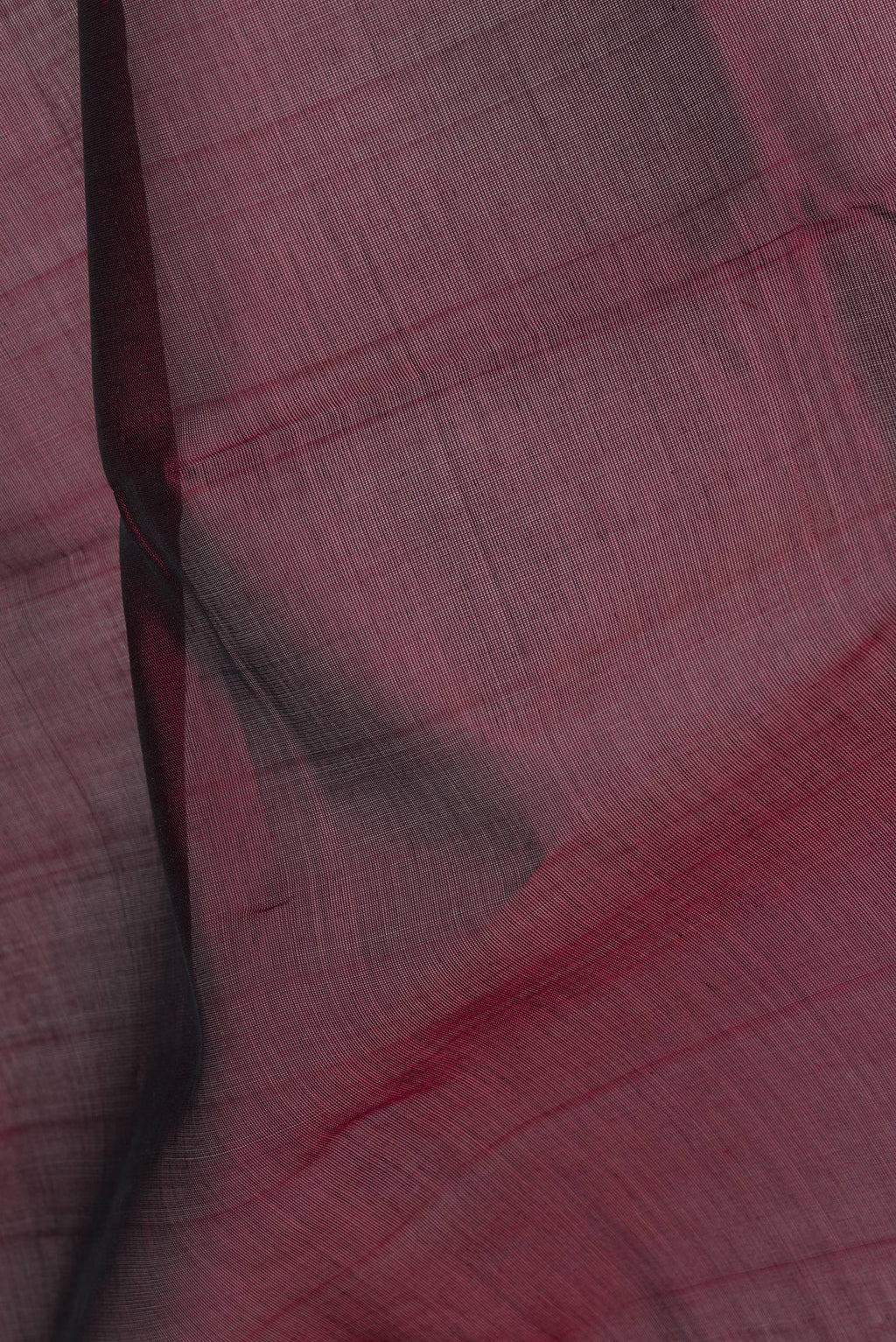 Close up of Maroon Silk Cotton Saree with Zari Butta on the body and Zari Border.  displaying folds