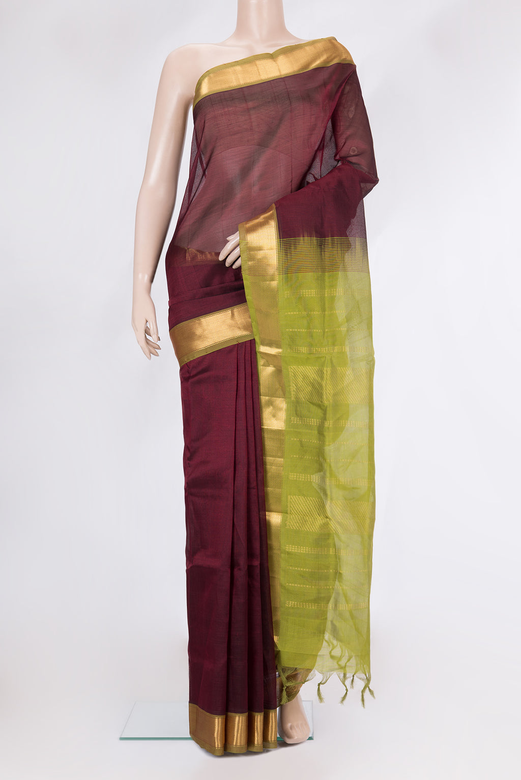 Maroon Silk Cotton Saree with Zari Butta on the body and Zari Border.  displayed on a mannequin