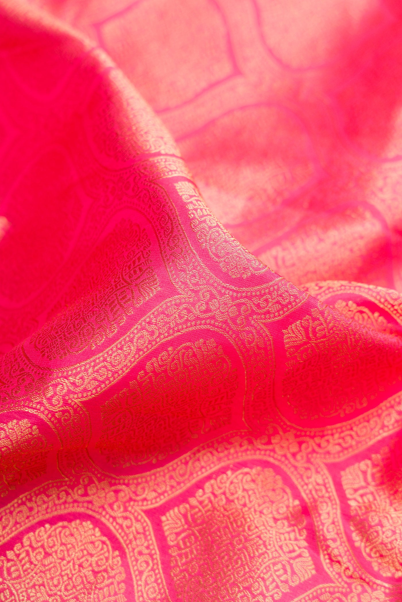 Close up of Pink Kanjivaram Silk Saree with Zari Brocade on the body and Zari Border.  displaying folds