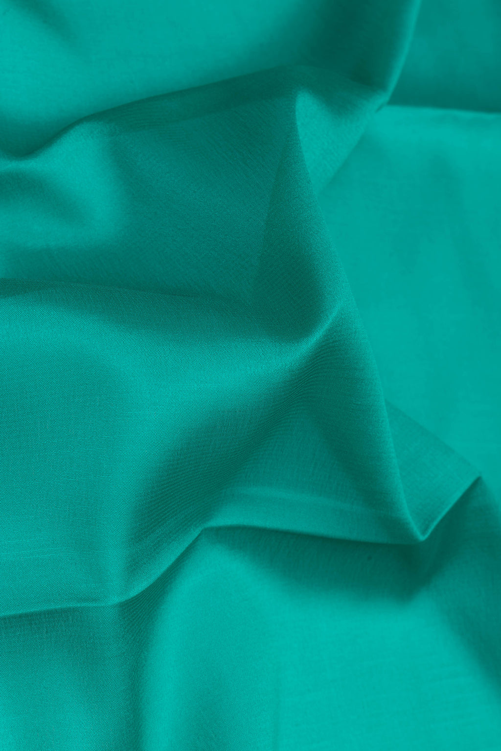 Close up of Sea Green Mysore Silk Saree with Plain Body and Zari Border.  displaying folds