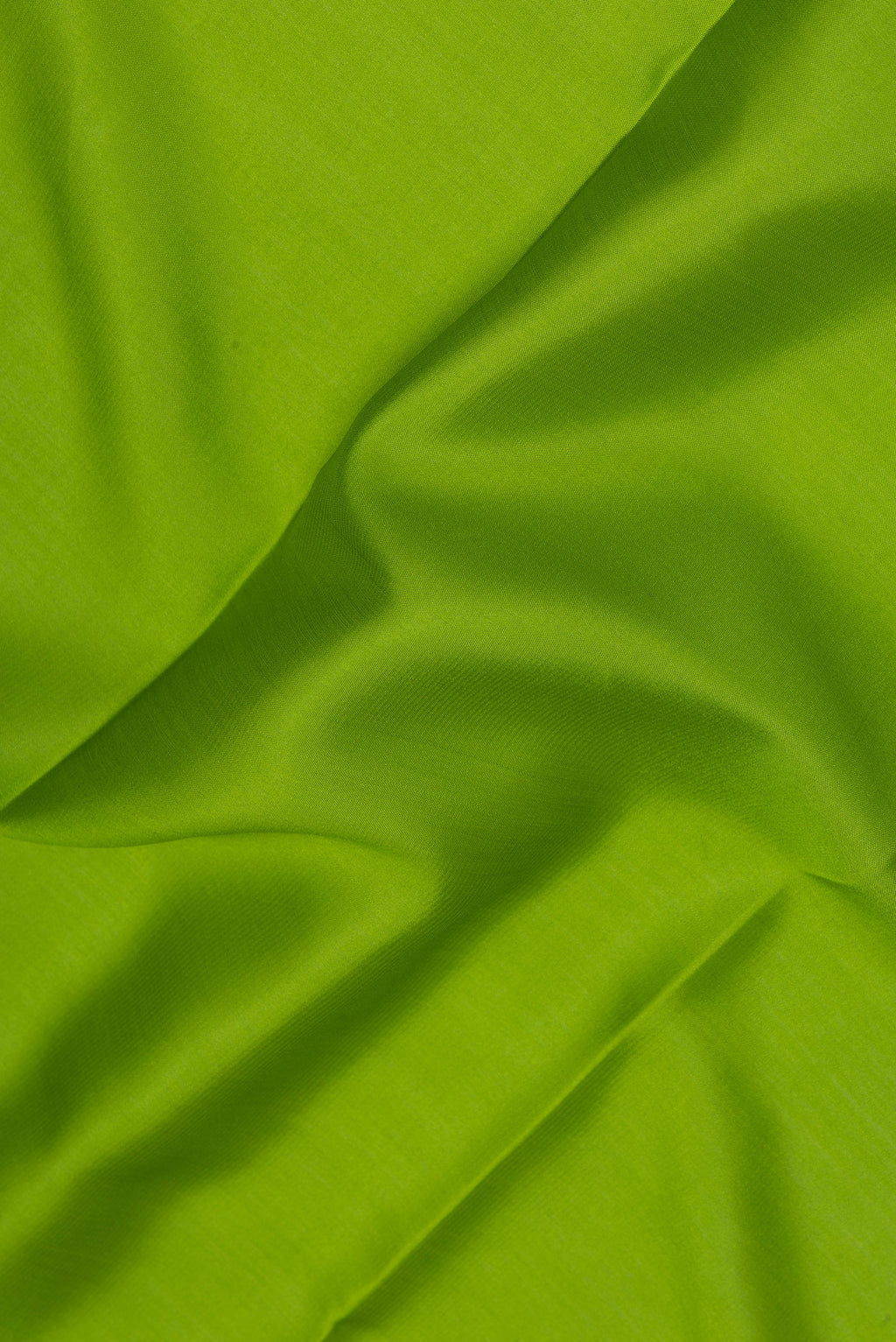 Close up of Parrot Green Mysore Silk Saree with Plain Body and Zari Border.  displaying folds