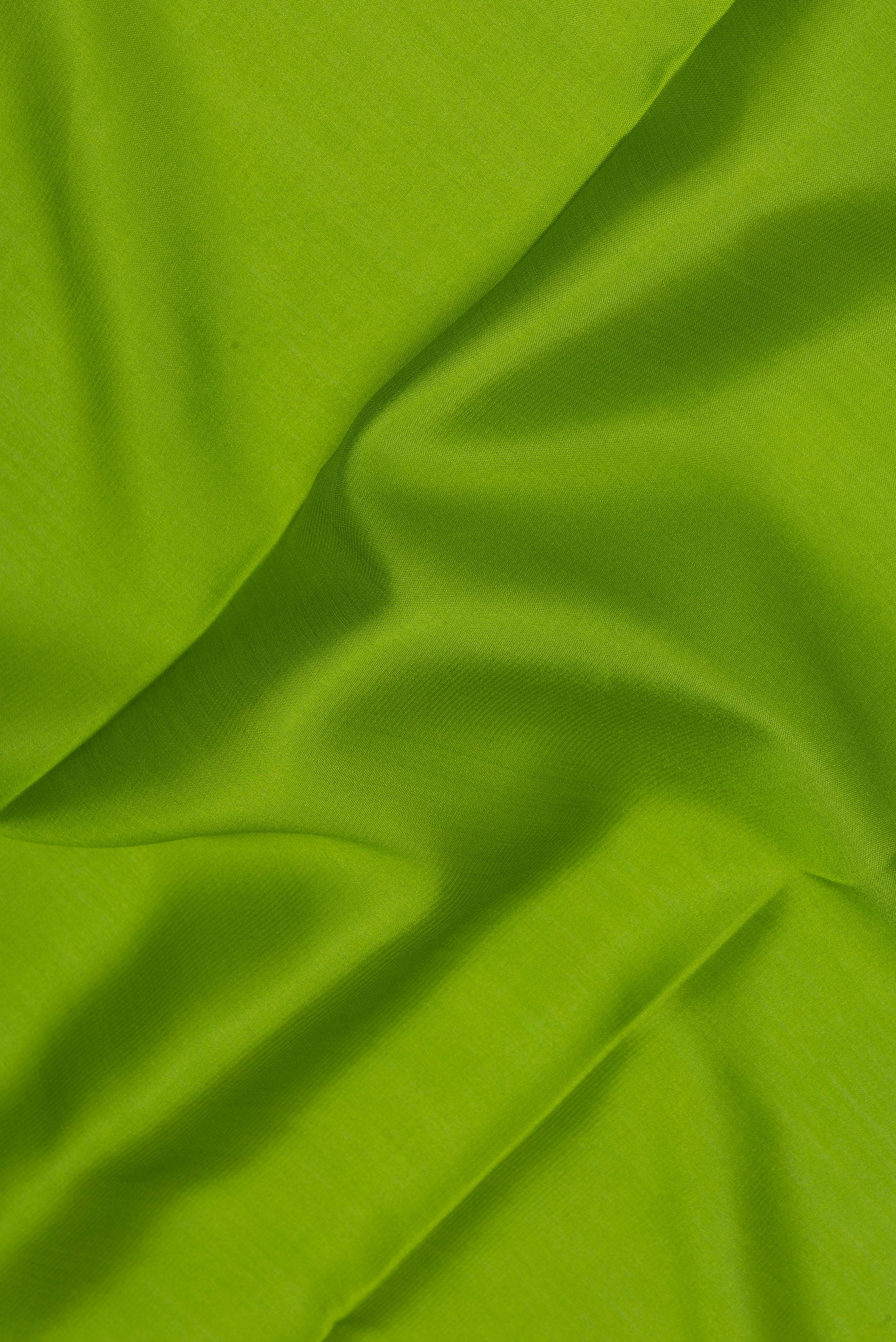 Close up of Parrot Green Mysore Silk Saree with Plain Body and Zari Border.  displaying folds