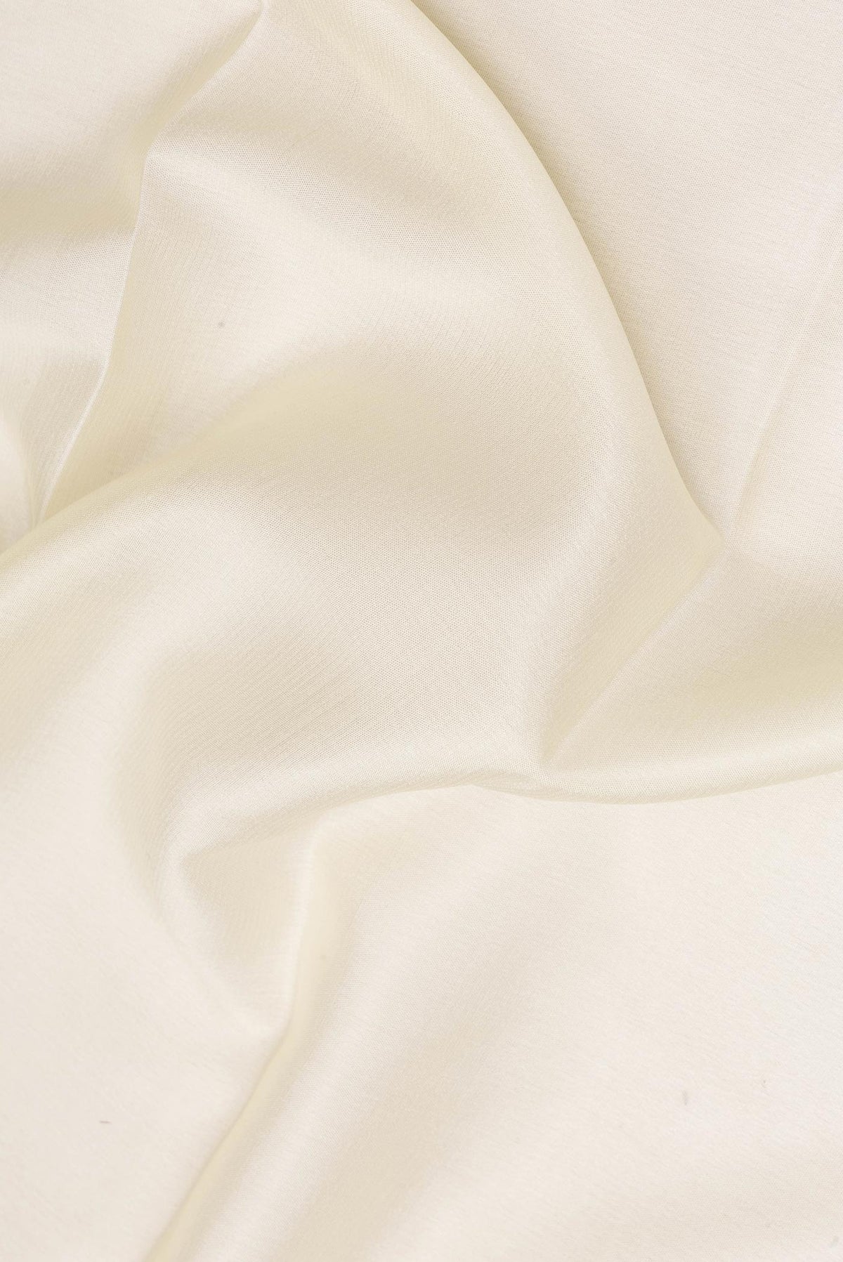 Close up of Off White Mysore Crepe Saree with Plain Body and Zari Border.  displaying folds