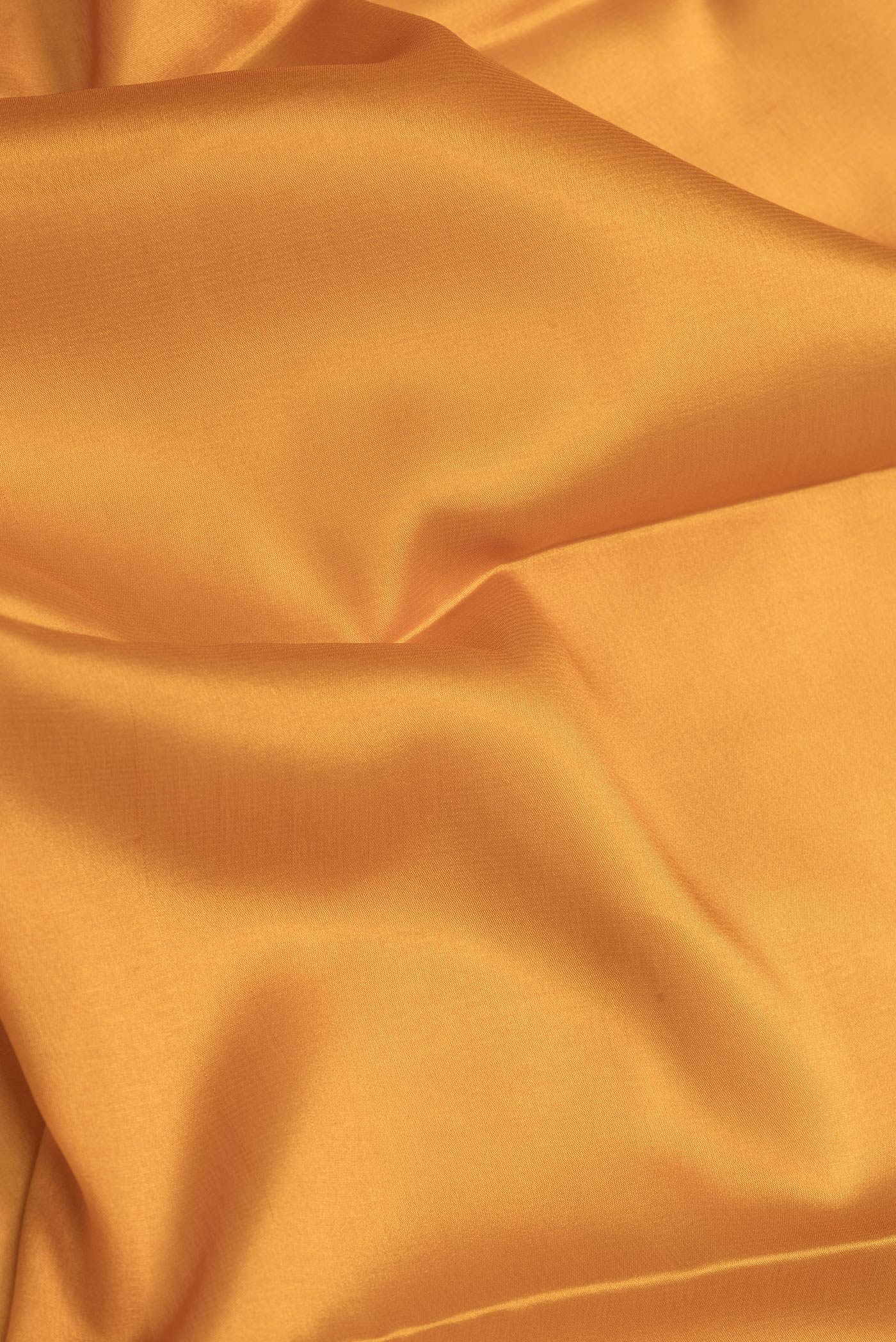 Close up of Mustard Dual Tone Mysore Silk Saree with Plain Body and Zari Border.  displaying folds
