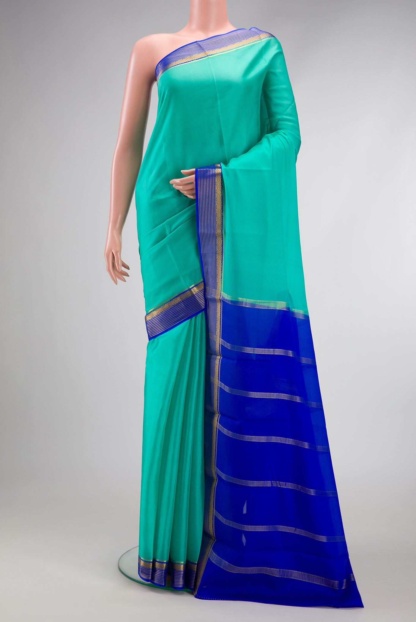 Sea Green Mysore Crepe Saree with Plain Body and Zari Border.  displayed on a mannequin