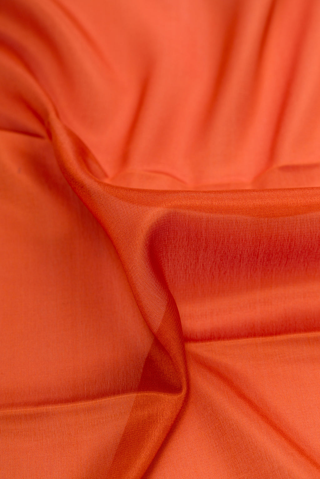 Close up of Rust Dual Tone Mysore Crepe Saree with Plain Body and Zari Border.  displaying folds