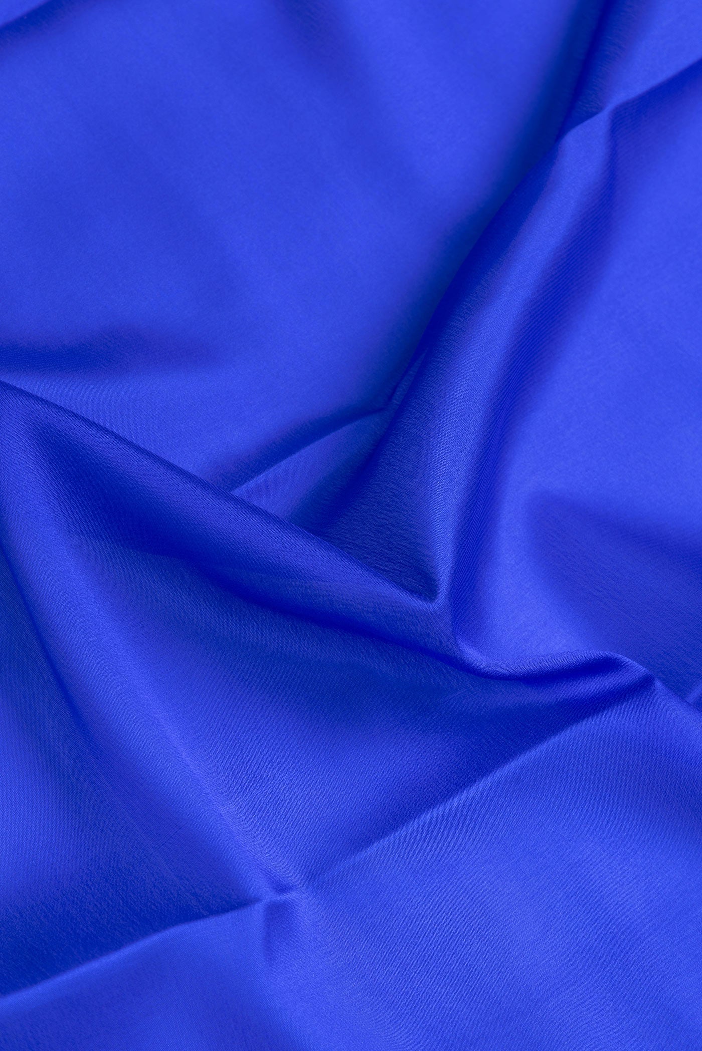 Close up of Royal Blue Dual Tone Mysore Crepe Saree with Plain Body and Zari Border.  displaying folds