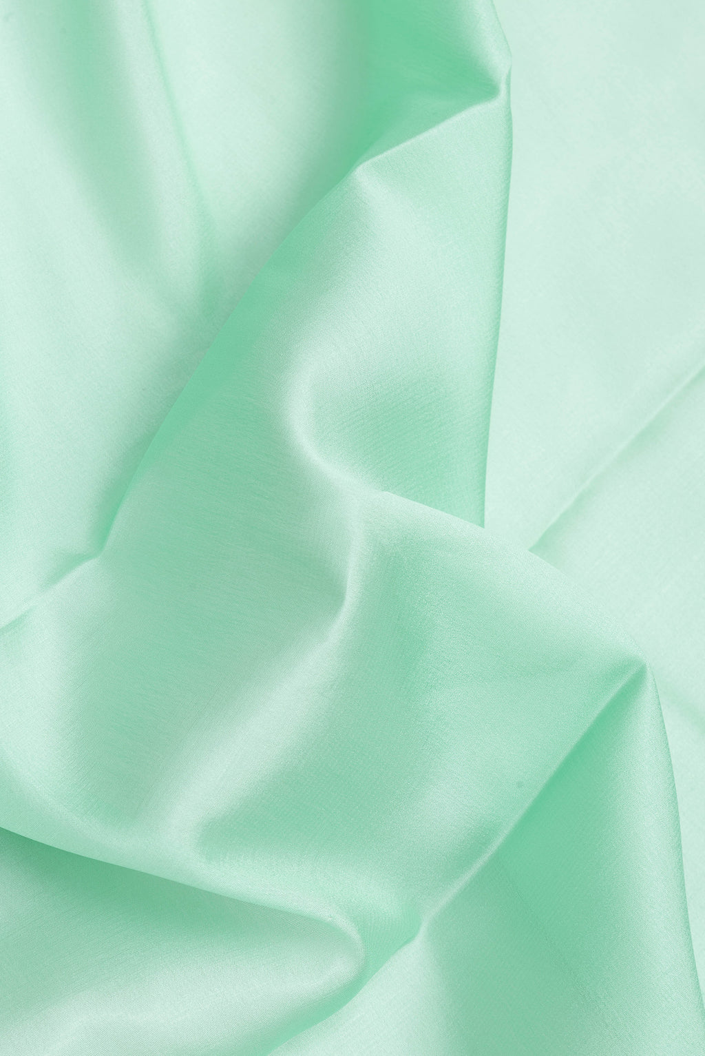 Close up of Sea Green Dual Tone Mysore Crepe Saree with Plain Body and Zari Border.  displaying folds