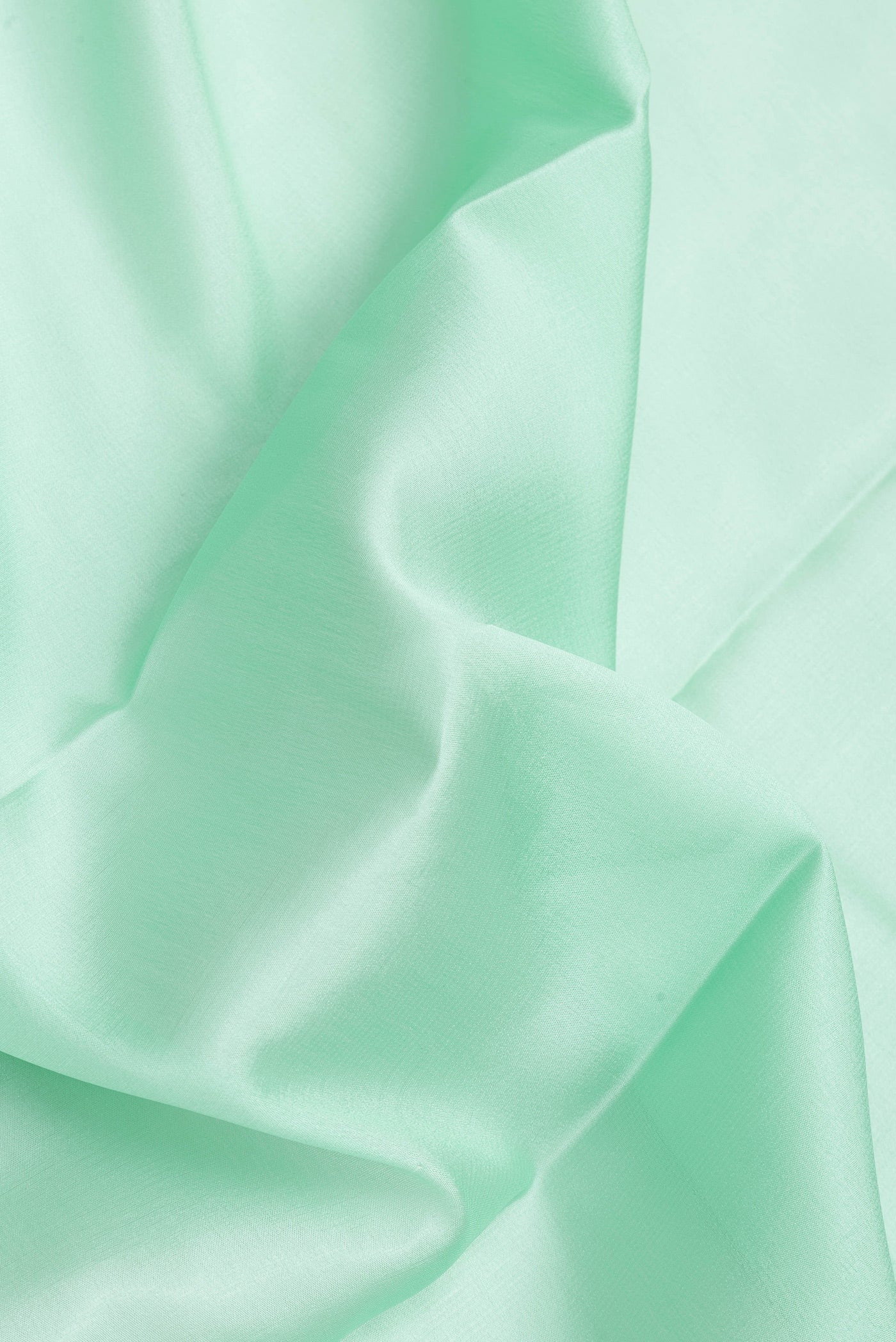 Close up of Sea Green Dual Tone Mysore Crepe Saree with Plain Body and Zari Border.  displaying folds