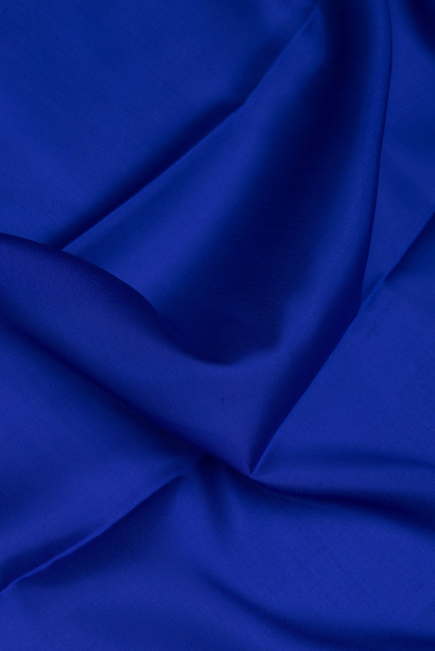 Close up of Royal Blue Mysore Crepe Saree with Plain Body and Zari Border.  displaying folds
