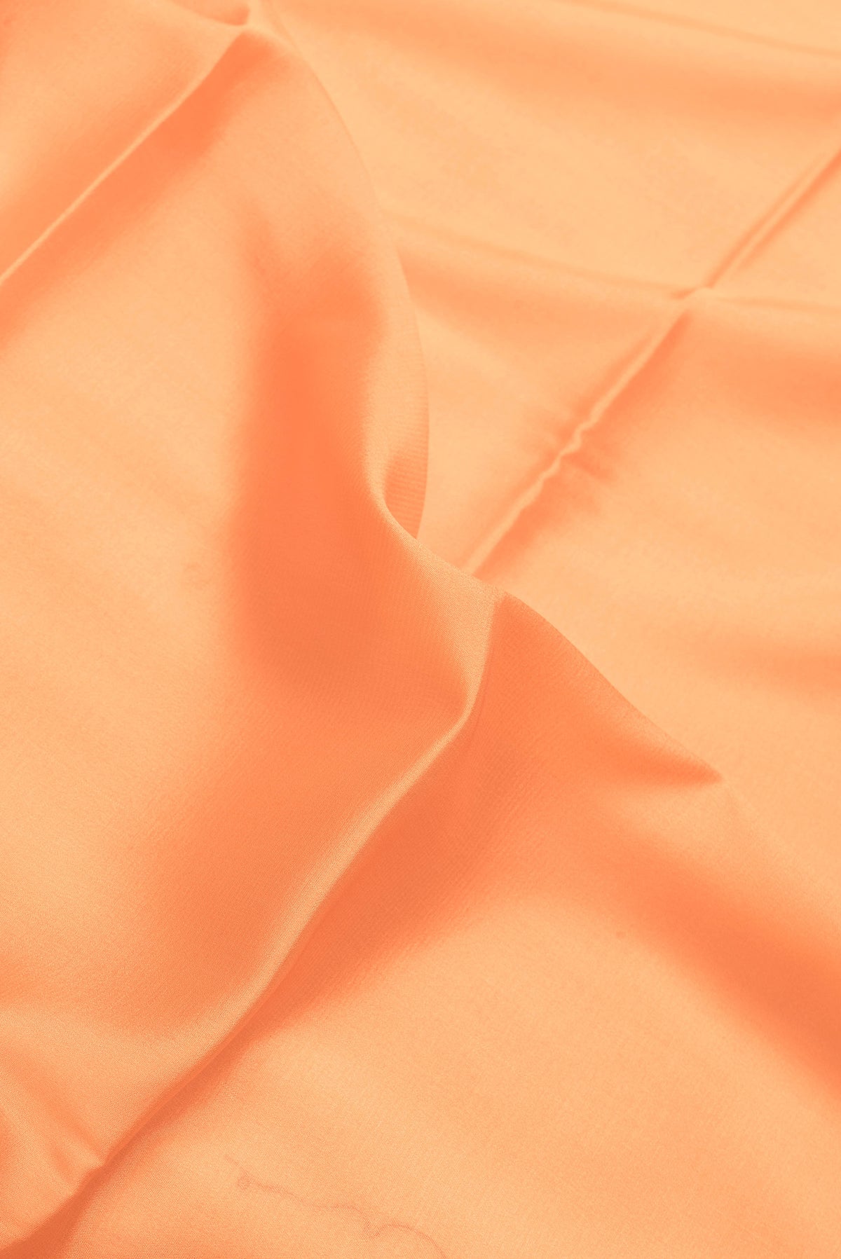 Close up of Peach Dual Tone Mysore Crepe Saree with Plain Body and Zari Border.  displaying folds