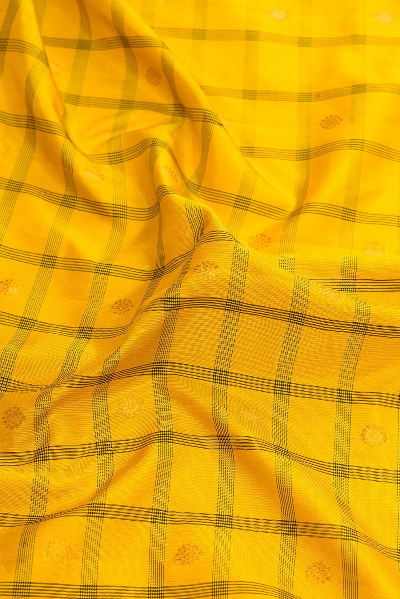 Close up of Yellow Dual Tone Gadwal Silk Saree with Checked design on the body and Temple Border.  displaying folds