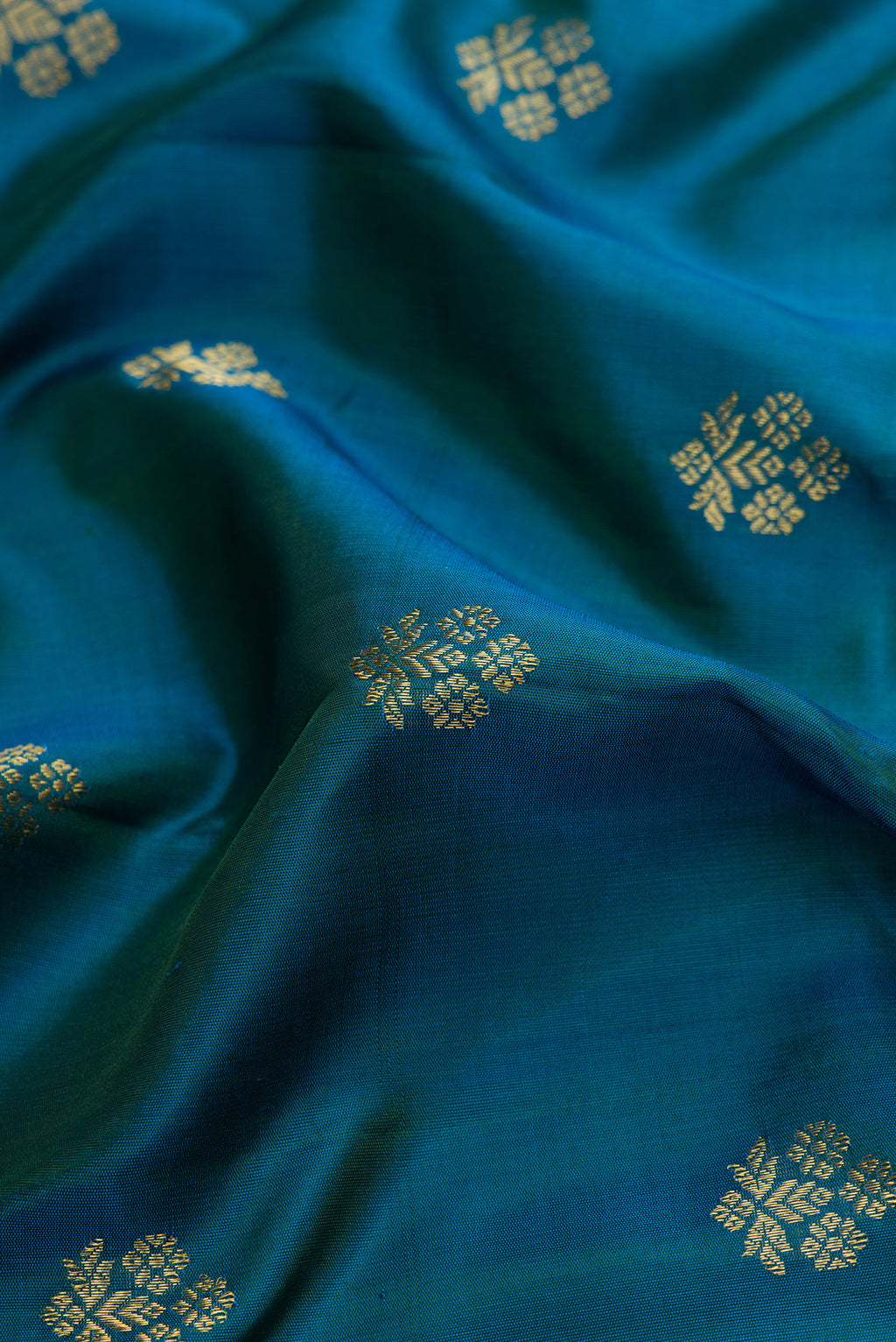 Close up of Peacock Blue Dual Tone Gadwal Silk Saree with Zari Butta on the body and Zari Border.  displaying folds
