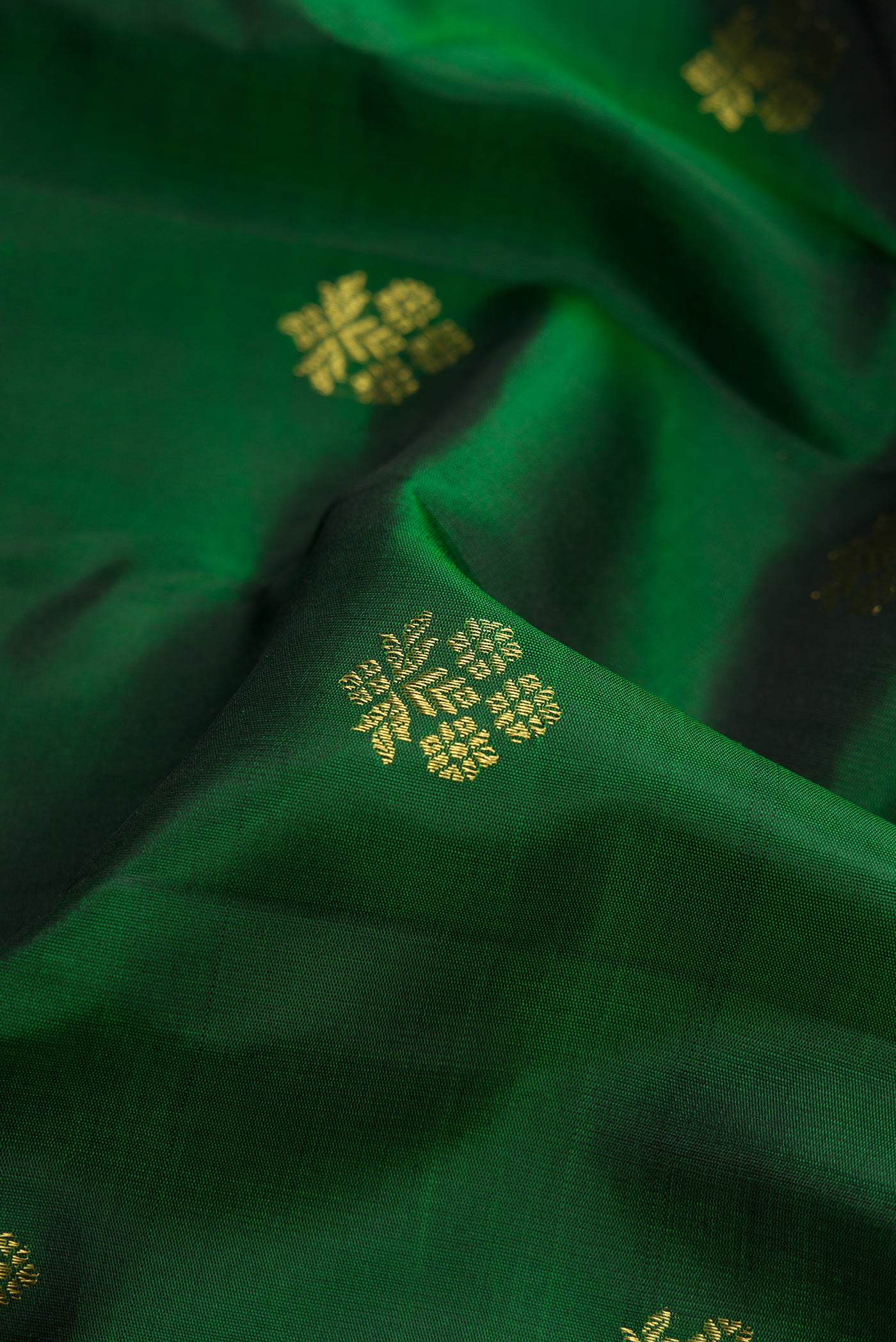 Close up of Bottle Green Gadwal Silk Saree with Zari Butta on the body and Zari Border.  displaying folds