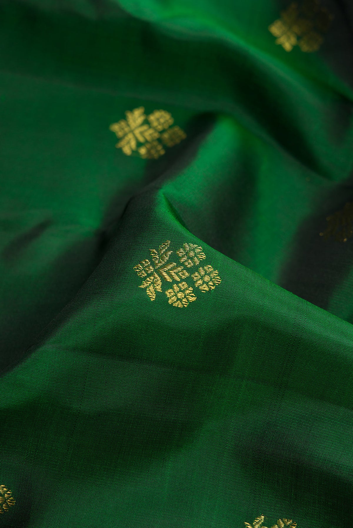 Close up of Bottle Green Gadwal Silk Saree with Zari Butta on the body and Zari Border.  displaying folds