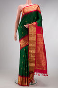 Bottle Green Gadwal Silk Saree with Zari Butta on the body and Zari Border.  displayed on a mannequin