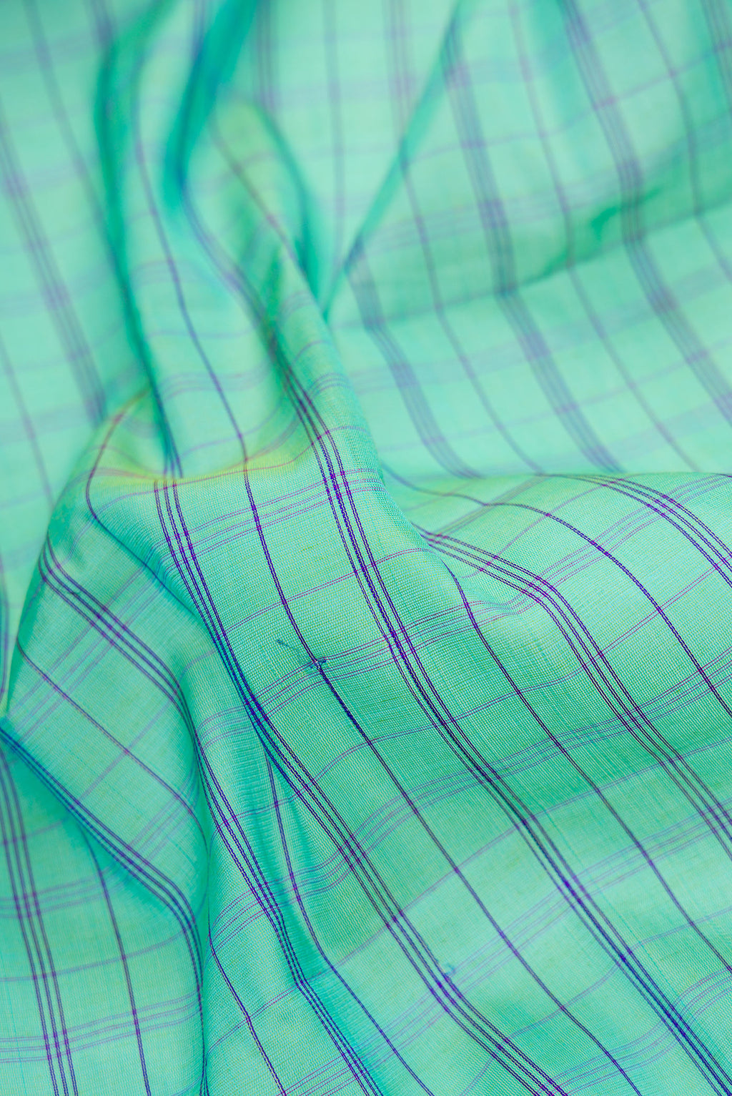 Close up of Sea Green Dual Tone Gadwal Silk Saree with Checked design on the body and Temple Border.  displaying folds