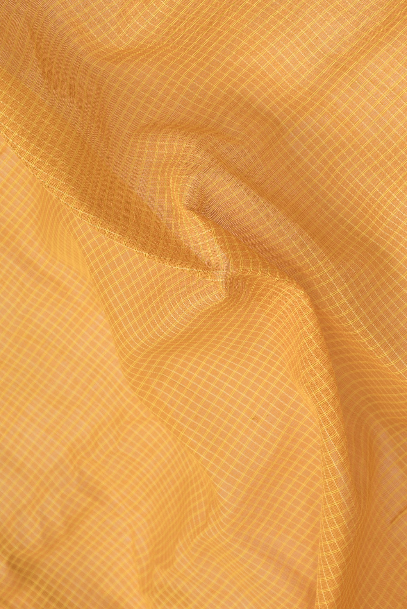 Close up of Mustard Dual Tone Kanjivaram Silk Saree with Checked design on the body and Zari Border.  displaying folds