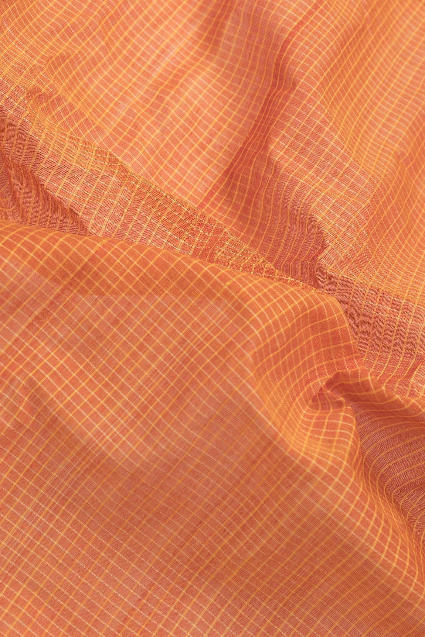 Close up of Orange Dual Tone Gadwal Silk Saree with Checked design on the body and Zari Border.  displaying folds