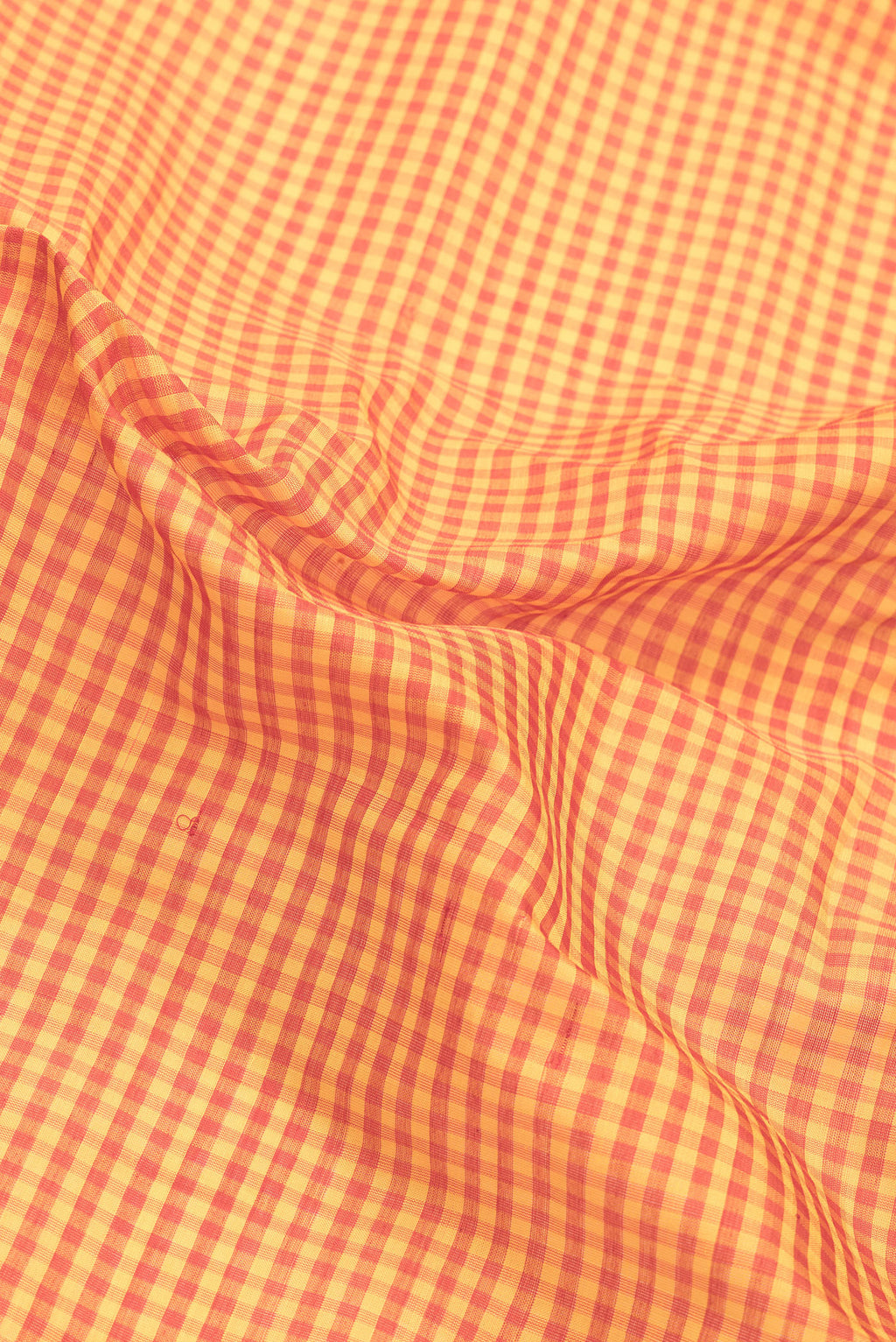 Close up of Orange Dual Tone Gadwal Silk Saree with Checked design on the body and Zari Border.  displaying folds