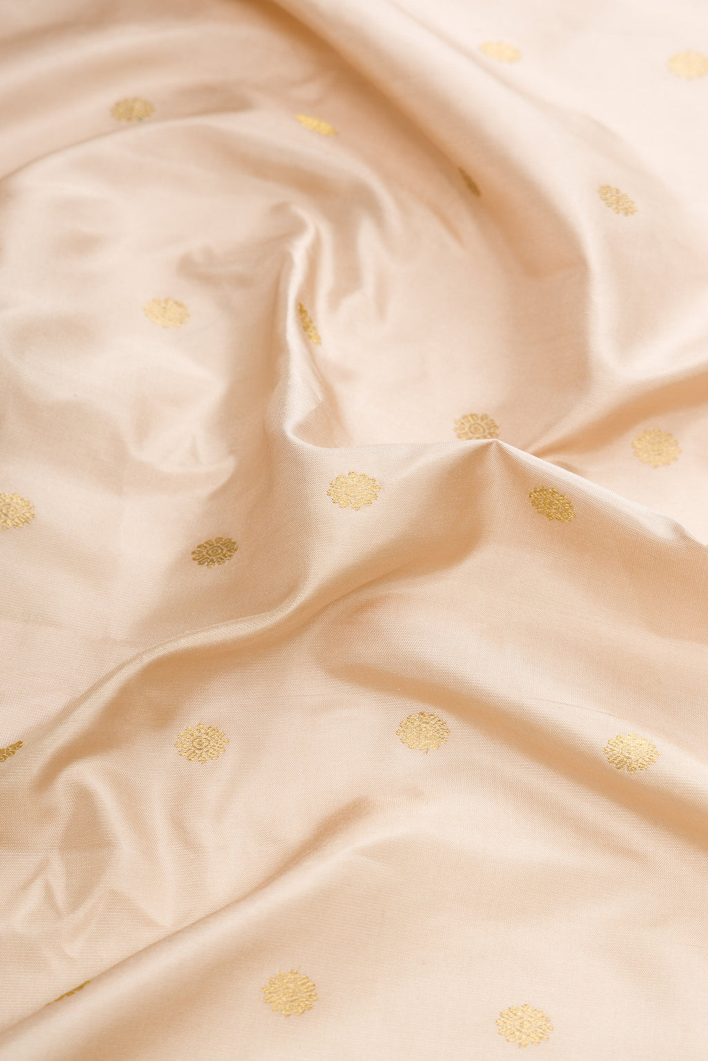 Close up of Beige Dual Tone Gadwal Silk Saree with Zari Butta on the body and Temple Border.  displaying folds