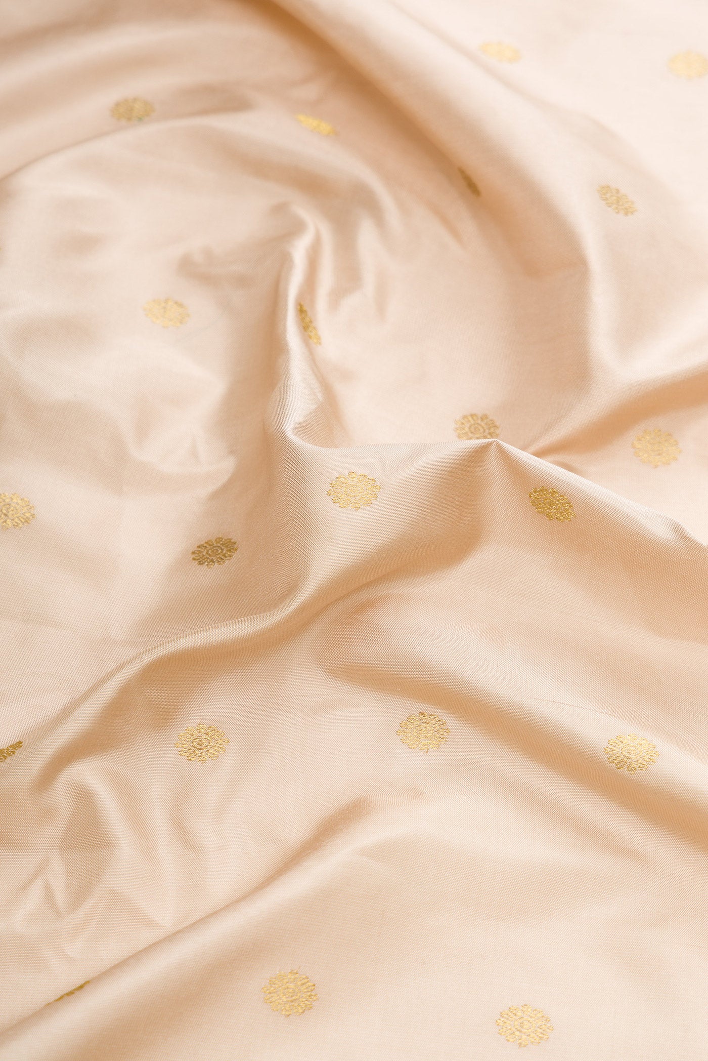 Close up of Beige Dual Tone Gadwal Silk Saree with Zari Butta on the body and Temple Border.  displaying folds