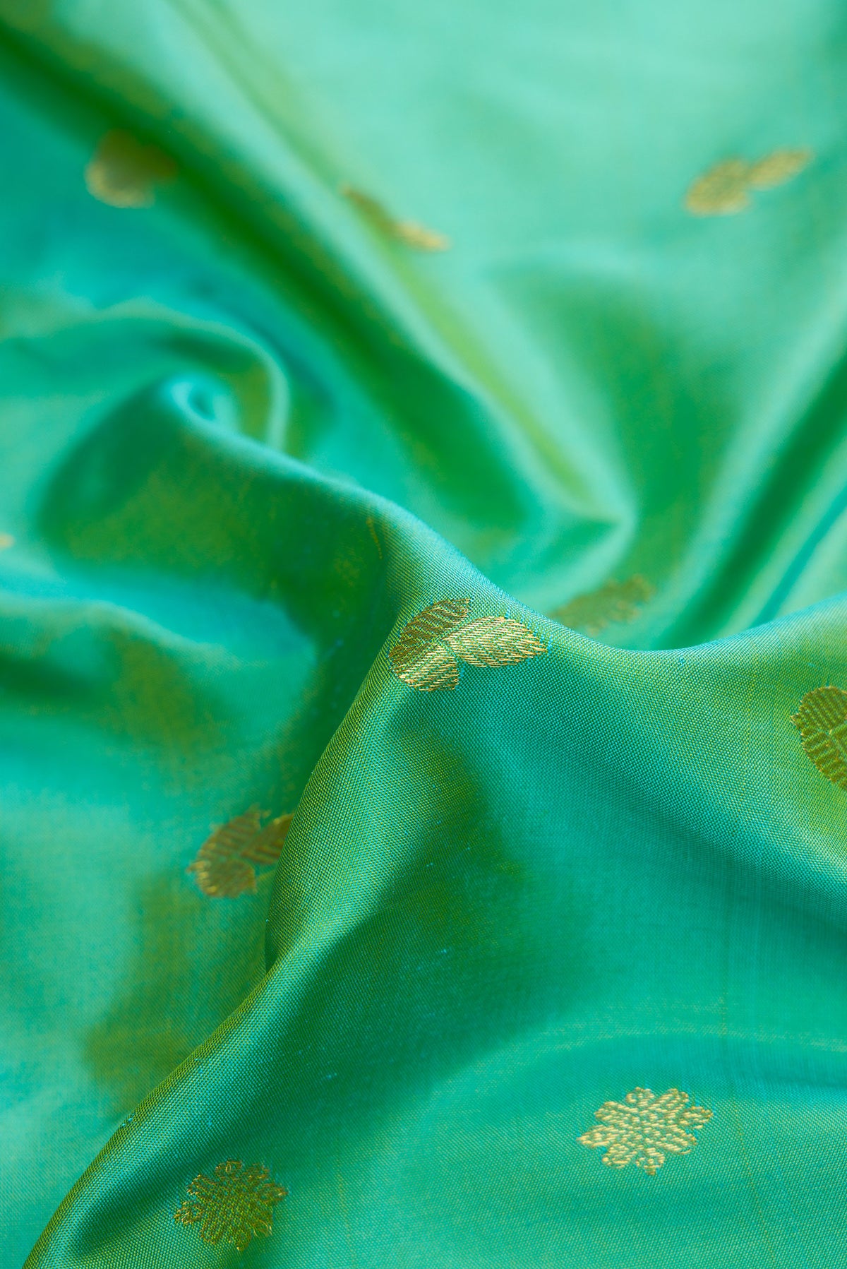Close up of Light Green Dual Tone Gadwal Silk Saree with Zari Butta on the body and Zari Border.  displaying folds