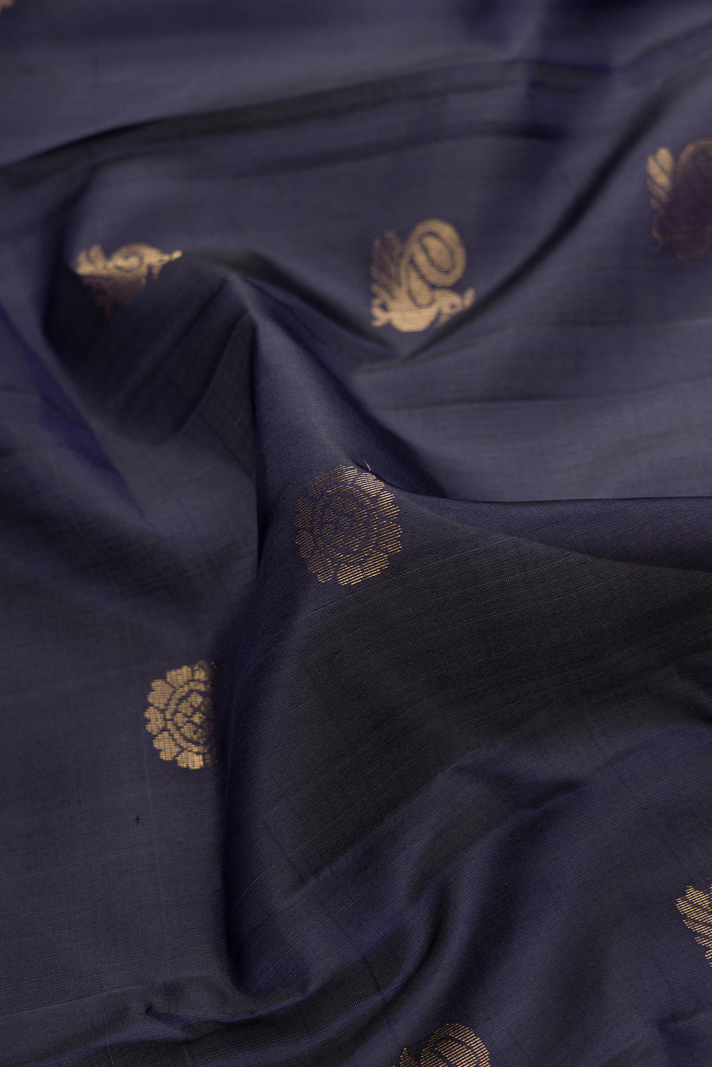 Close up of Navy Blue Dual Tone Soft Silk Saree with Zari Butta on the body and Zari Border.  displaying folds