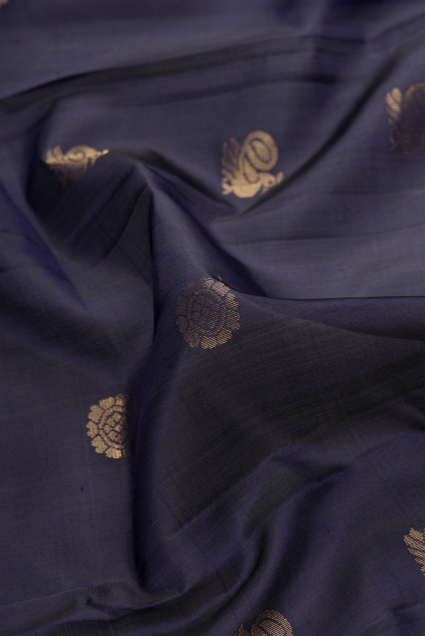 Close up of Navy Blue Dual Tone Soft Silk Saree with Zari Butta on the body and Zari Border.  displaying folds