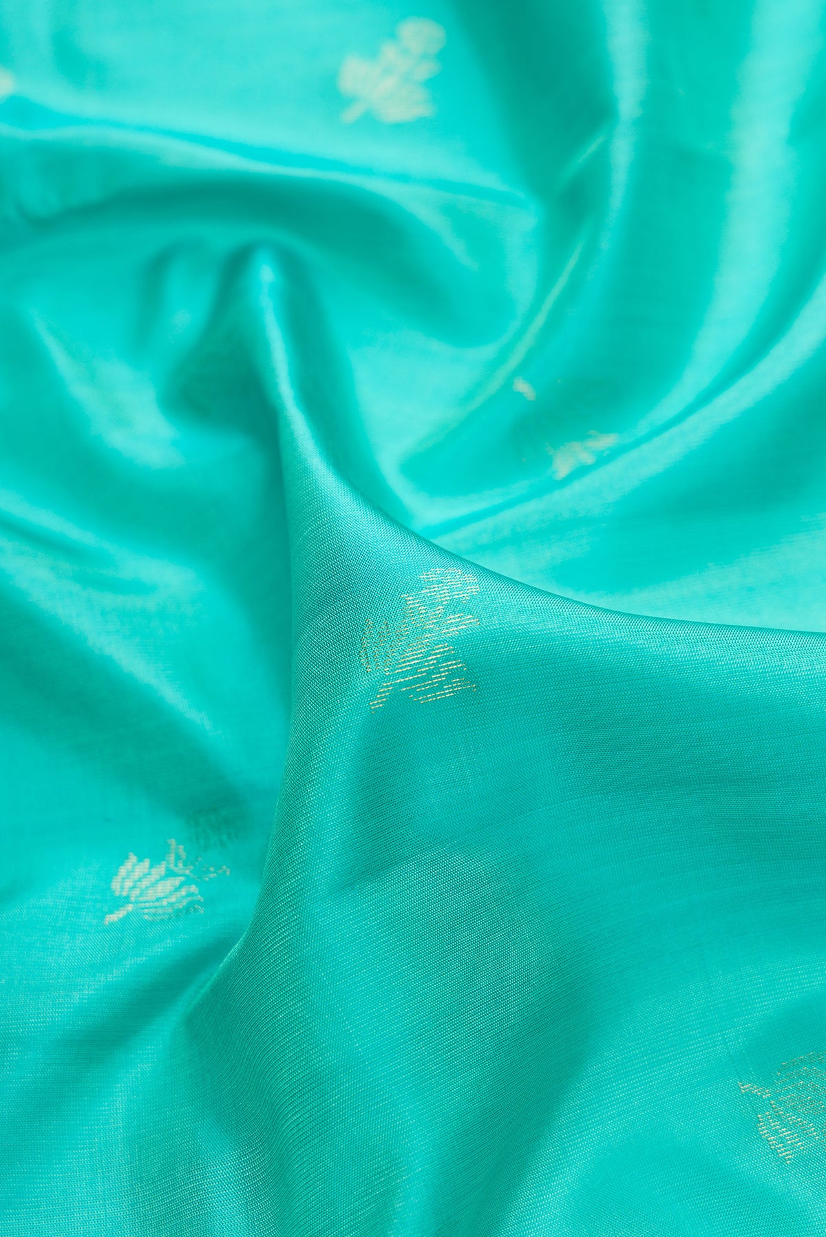 Close up of Sea Green Dual Tone Soft Silk Saree with Zari Butta on the body and Zari Border.  displaying folds
