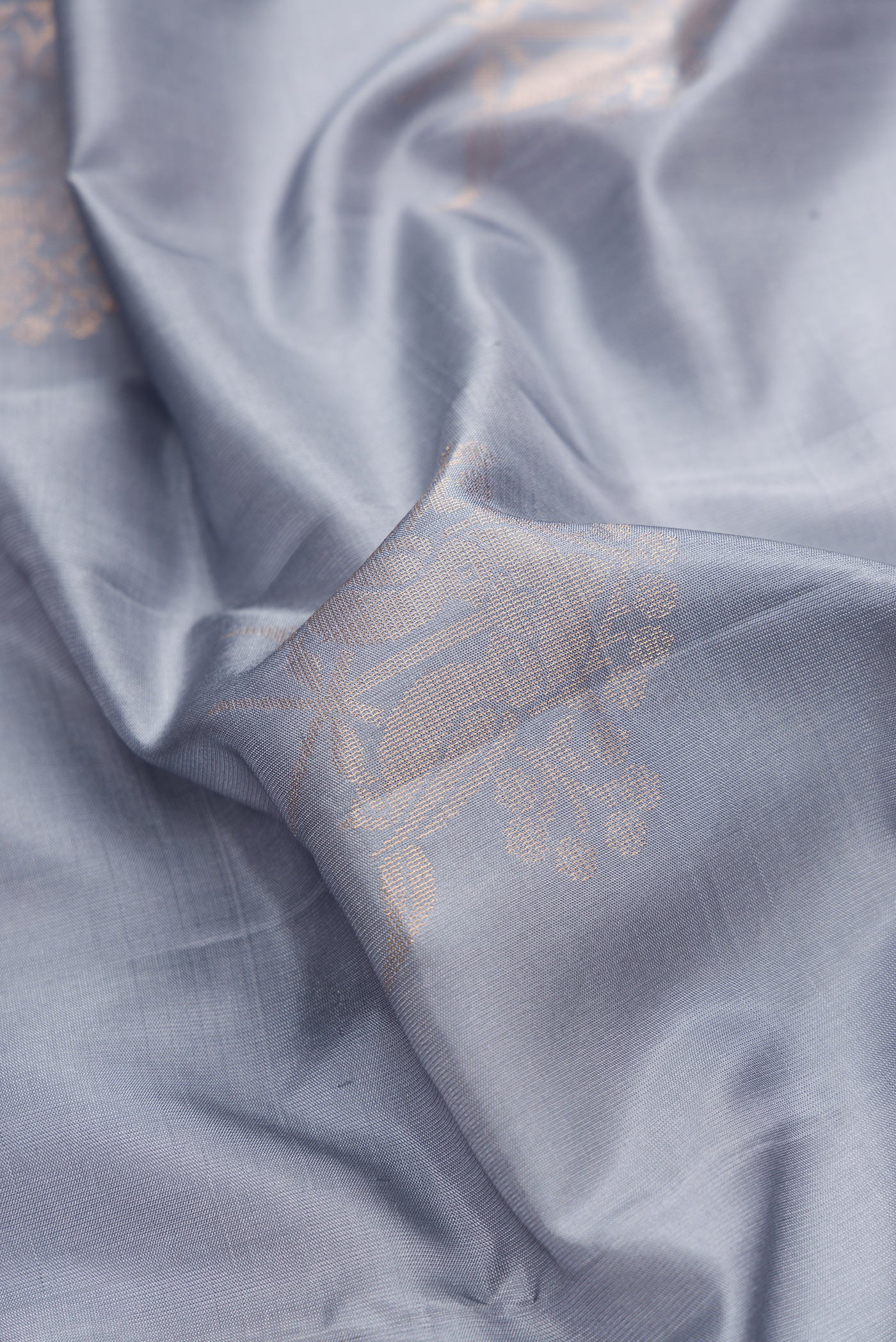 Close up of Grey Dual Tone Soft Silk Saree with Zari Butta on the body and Zari Border.  displaying folds