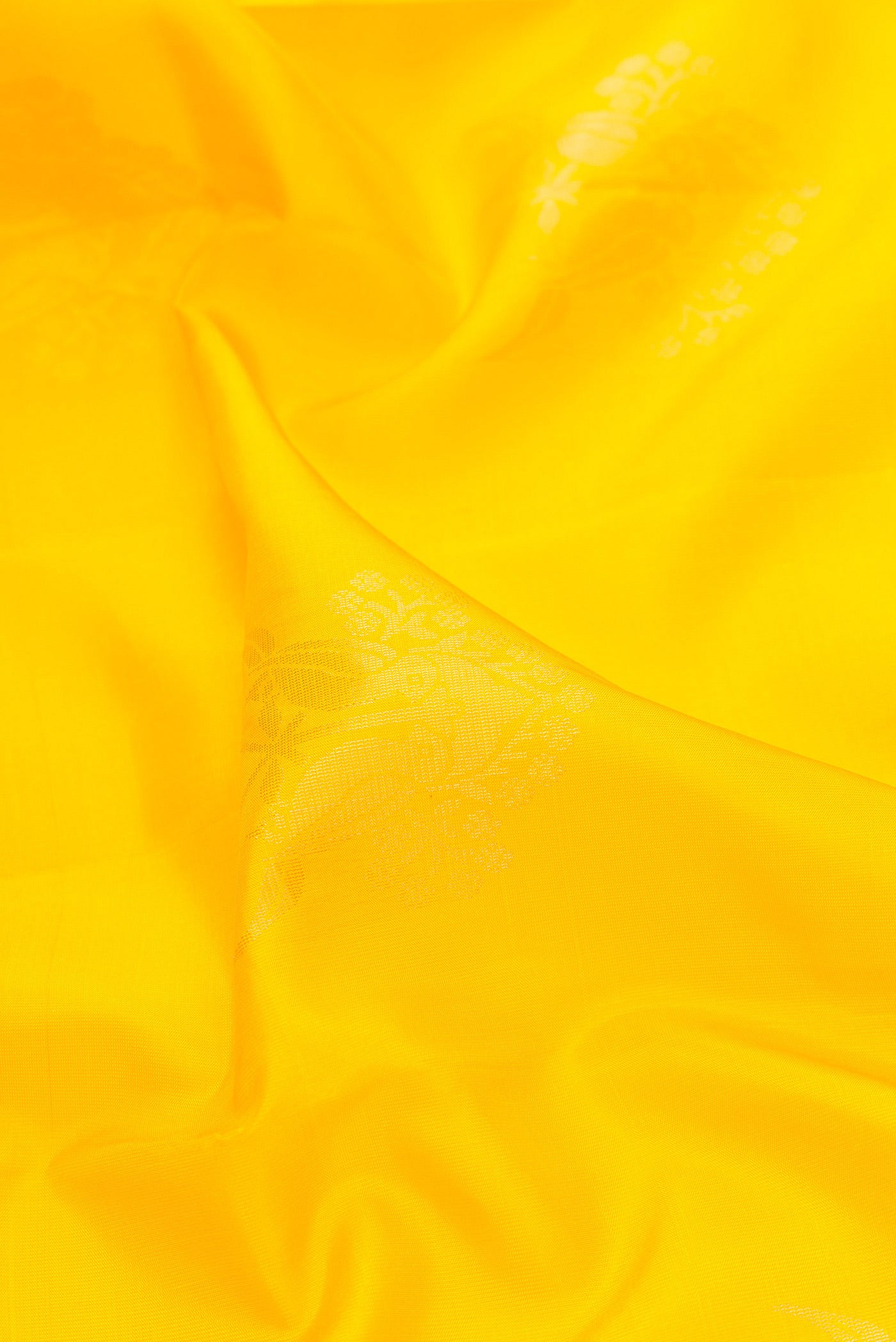 Close up of Yellow Dual Tone Soft Silk Saree with Zari Butta on the body and Zari Border.  displaying folds