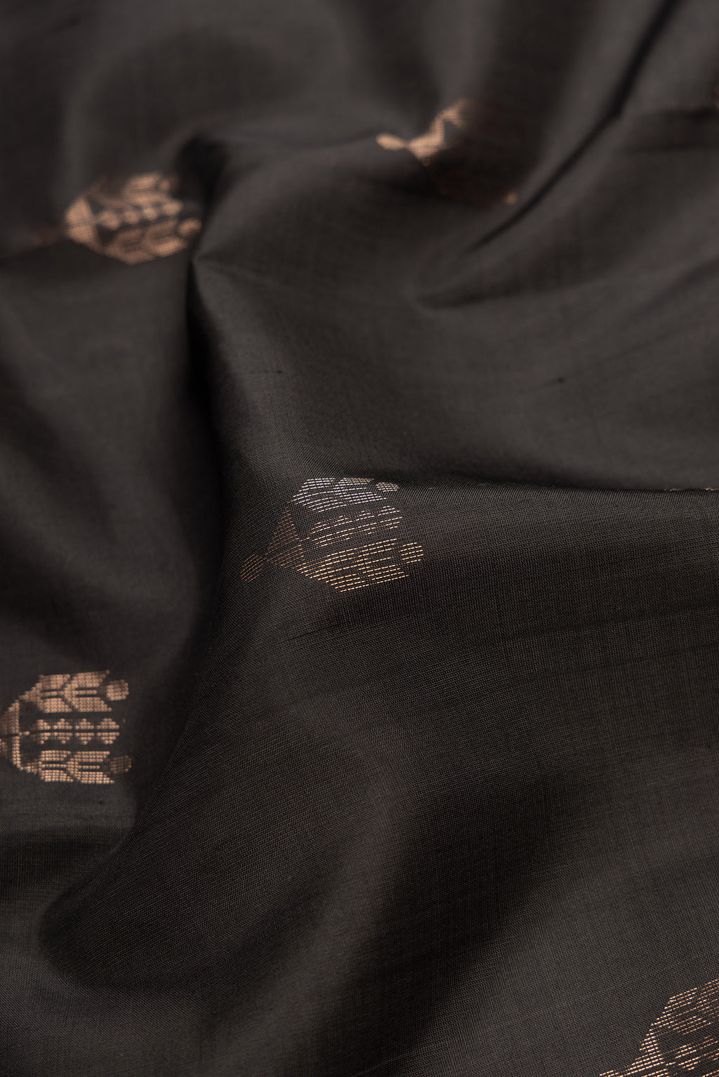 Close up of Black Dual Tone Soft Silk Saree with Zari Butta on the body and Zari Border.  displaying folds