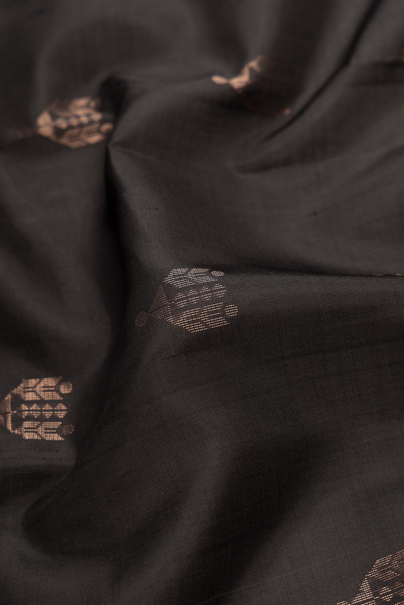 Close up of Black Dual Tone Soft Silk Saree with Zari Butta on the body and Zari Border.  displaying folds