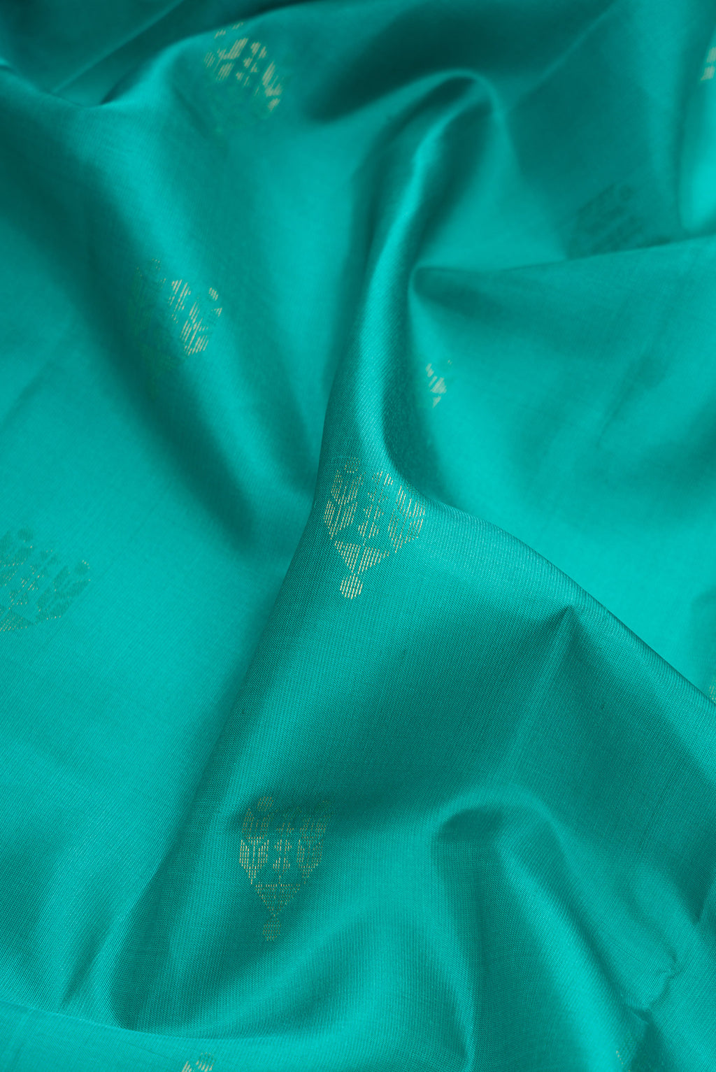Close up of Sea Green Dual Tone Soft Silk Saree with Zari Butta on the body and Zari Border.  displaying folds
