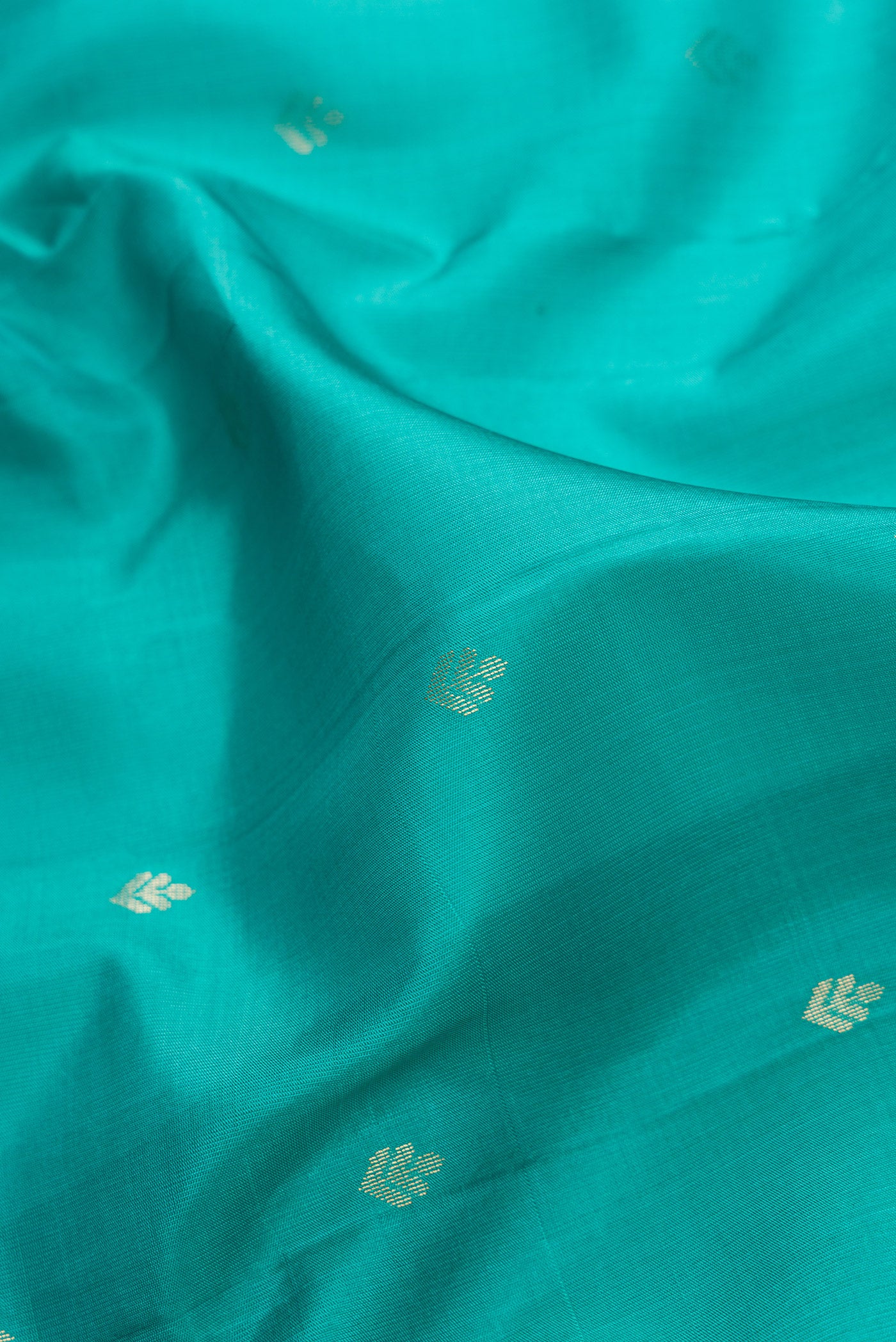 Close up of Green Dual Tone Soft Silk Saree with Zari Butta on the body and Zari Border.  displaying folds