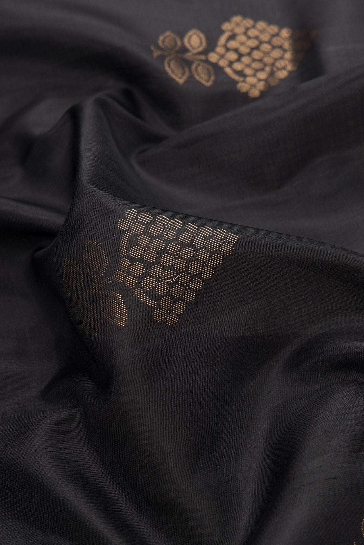 Close up of Black Dual Tone Soft Silk Saree with Zari Butta on the body and Zari Border.  displaying folds