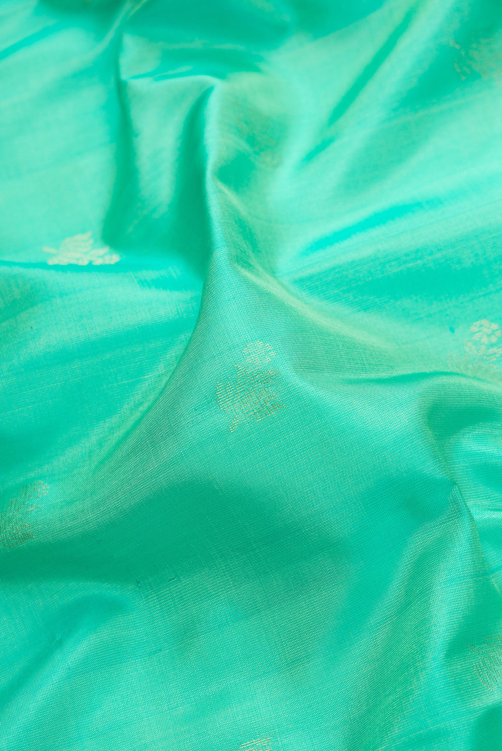 Close up of Sea Green Dual Tone Soft Silk Saree with Zari Butta on the body and Zari Border.  displaying folds