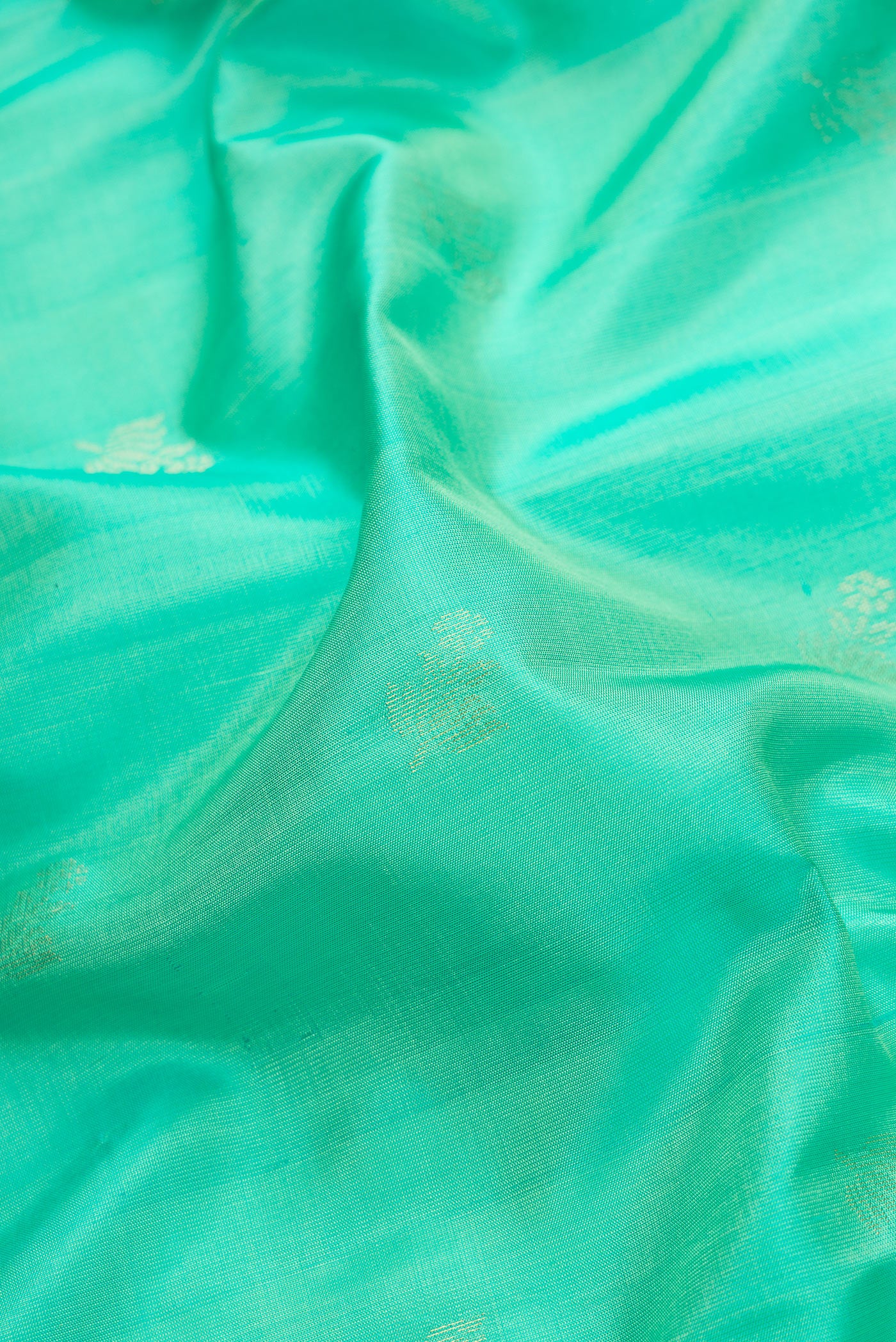 Close up of Sea Green Dual Tone Soft Silk Saree with Zari Butta on the body and Zari Border.  displaying folds
