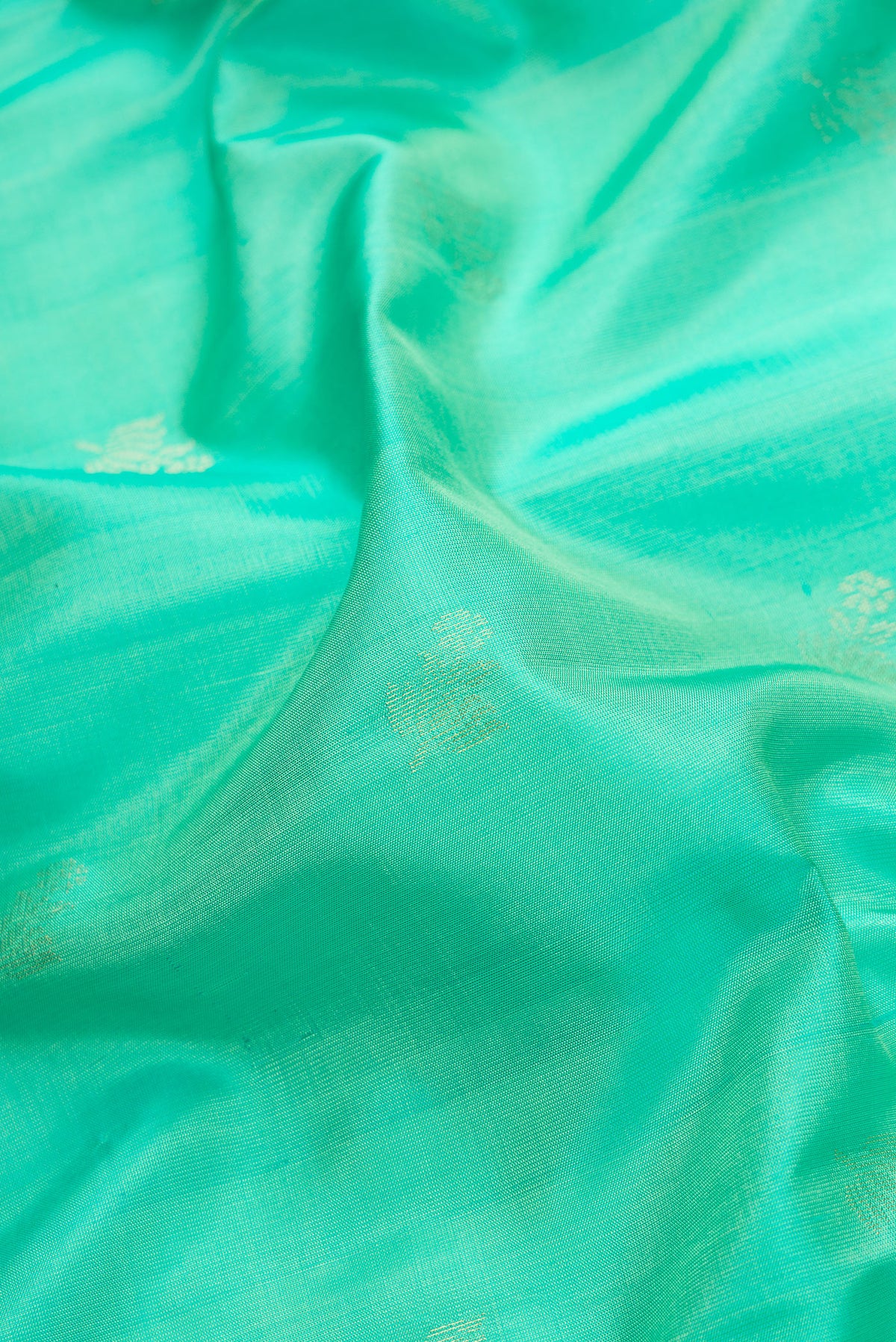 Close up of Sea Green Dual Tone Soft Silk Saree with Zari Butta on the body and Zari Border.  displaying folds