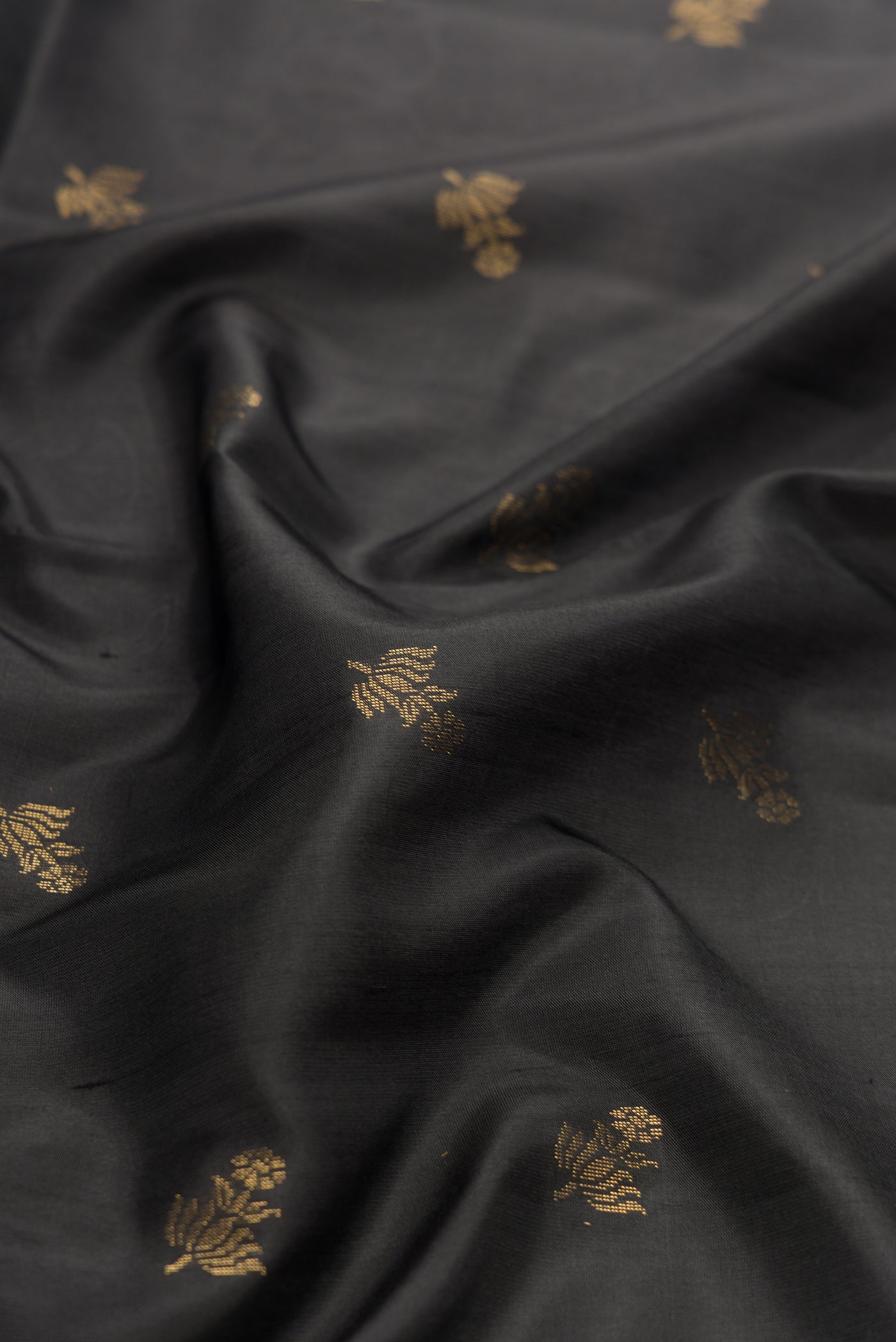 Close up of Black Dual Tone Soft Silk Saree with Zari Butta on the body and Zari Border.  displaying folds