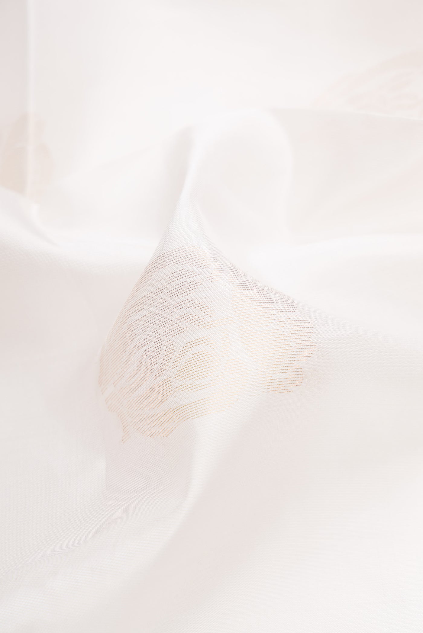 Close up of Off White Dual Tone Soft Silk Saree with Zari Butta on the body and Zari Border.  displaying folds