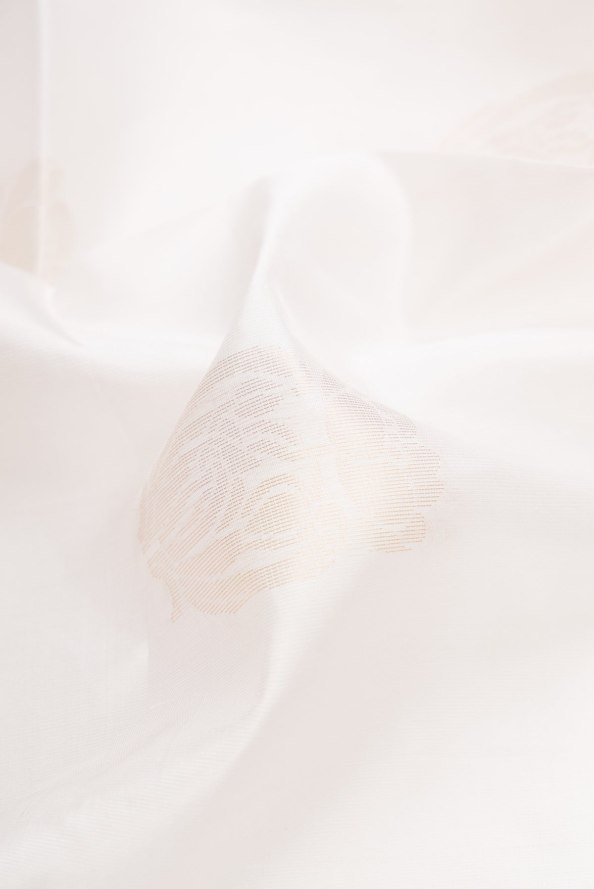 Close up of Off White Dual Tone Soft Silk Saree with Zari Butta on the body and Zari Border.  displaying folds