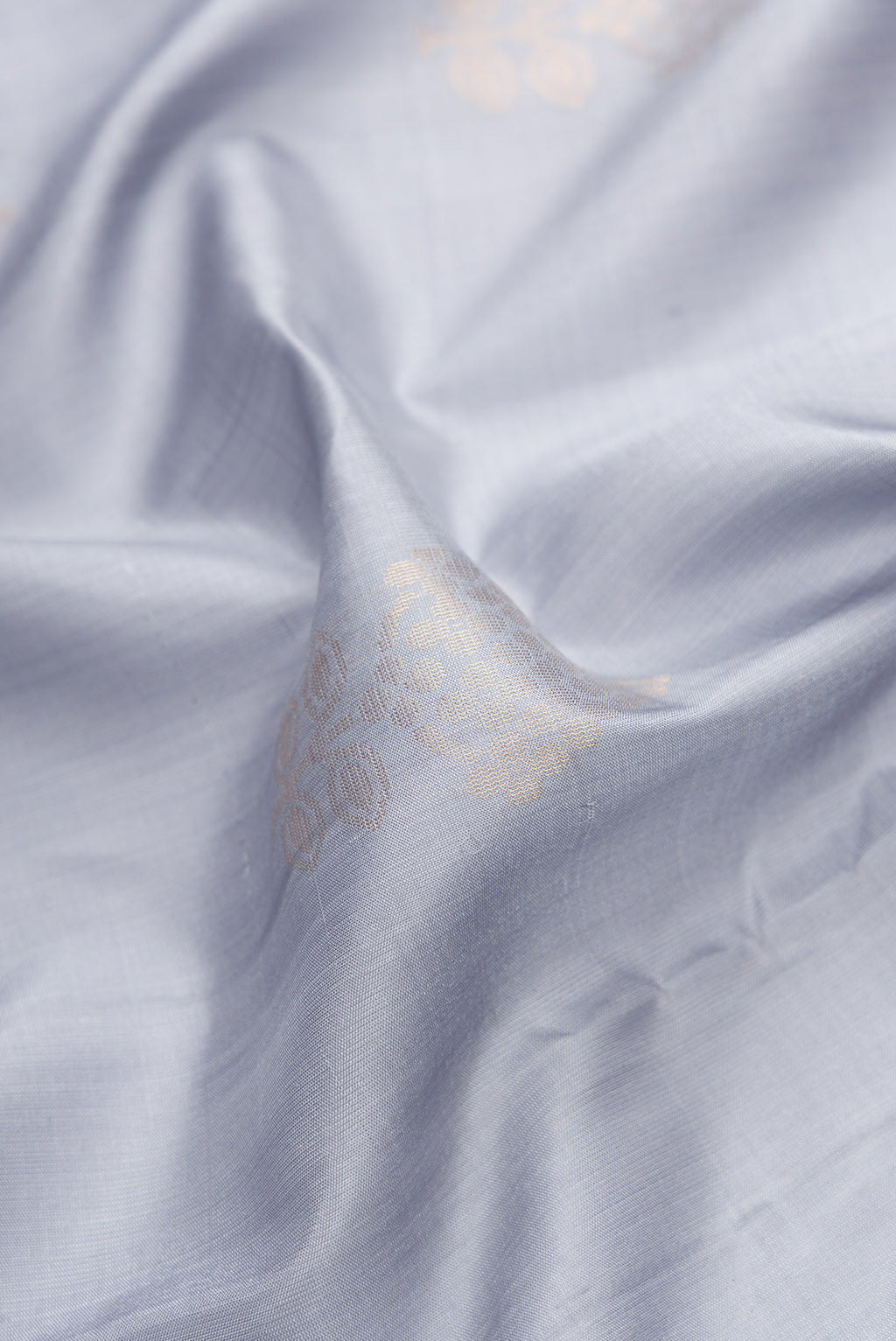 Close up of Grey Dual Tone Soft Silk Saree with Zari Butta on the body and Zari Border.  displaying folds
