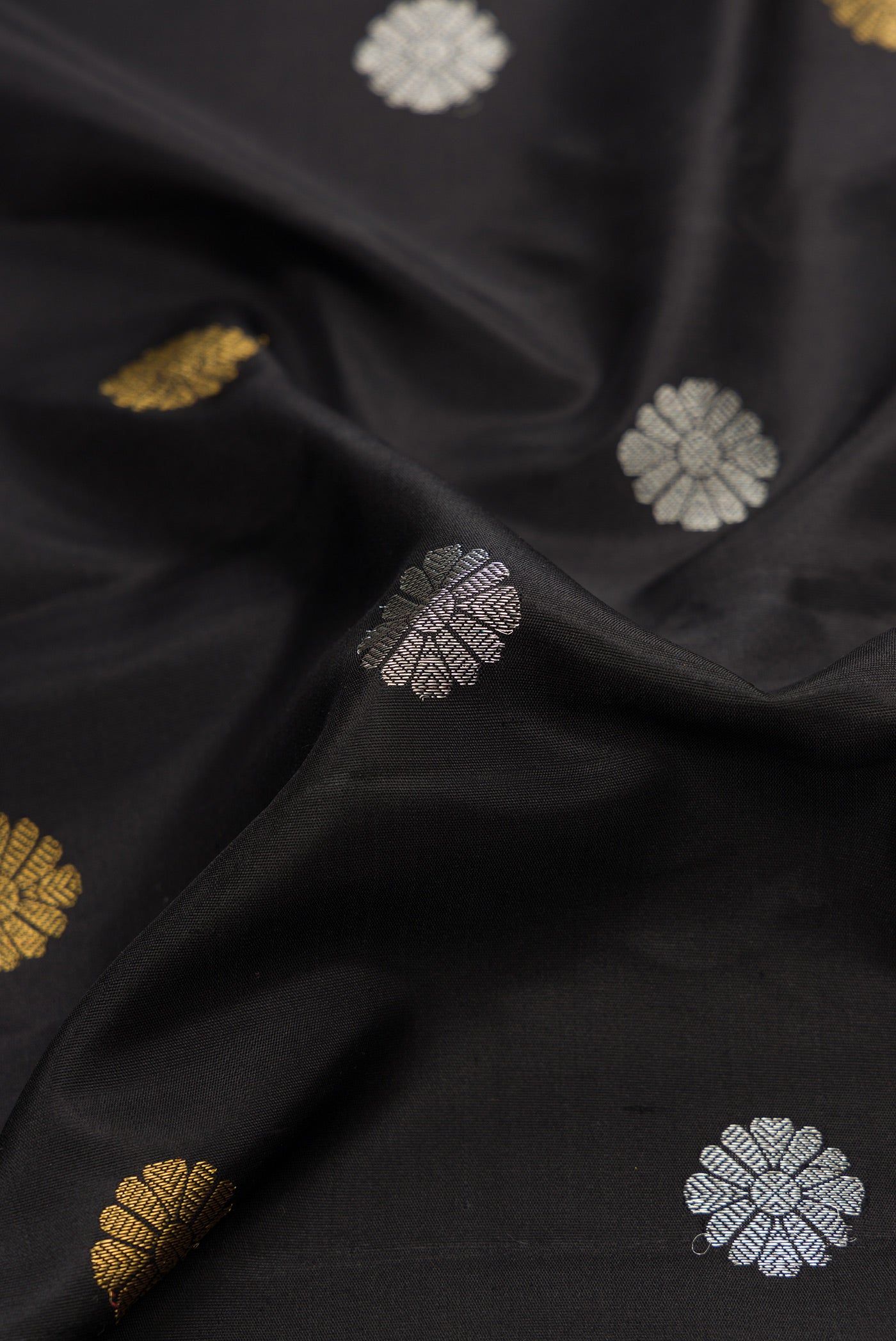 Close up of Black Dual Tone Gadwal Silk Saree with Zari Butta on the body and Zari Border.  displaying folds