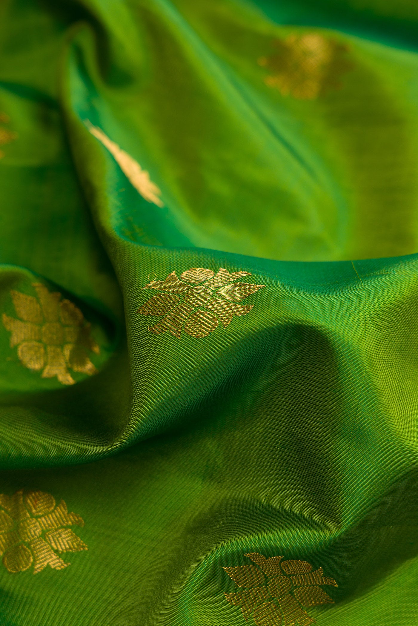 Close up of Green Dual Tone Gadwal Silk Saree with Zari Butta on the body and Zari Border.  displaying folds