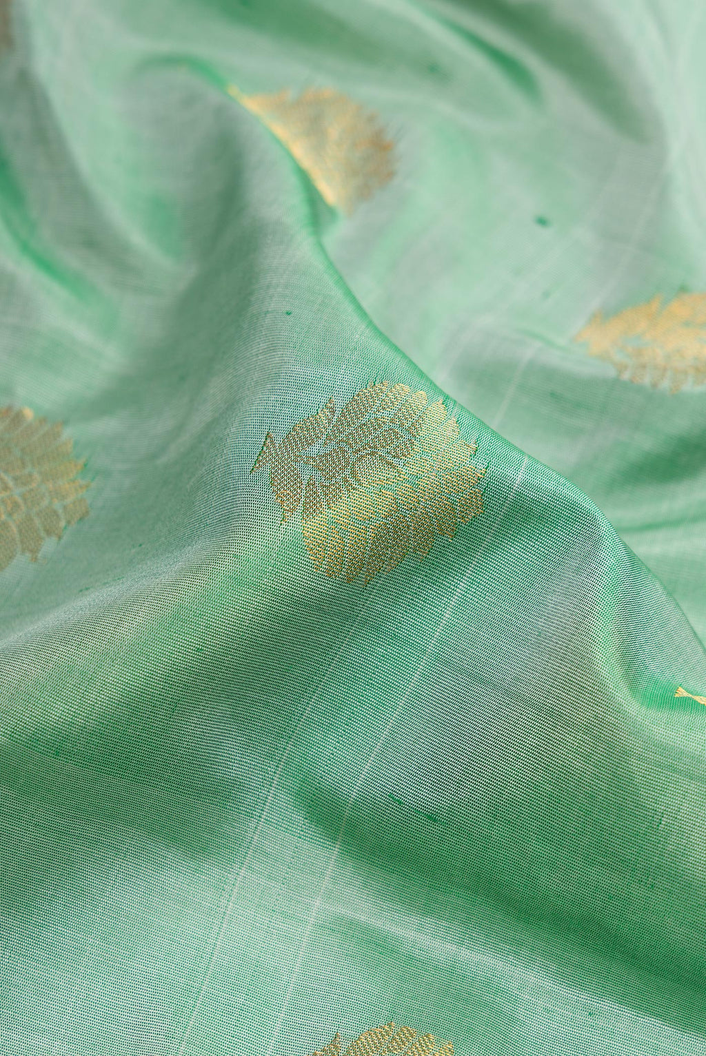 Close up of Light Green Dual Tone Gadwal Silk Saree with Zari Butta on the body and Zari Border.  displaying folds