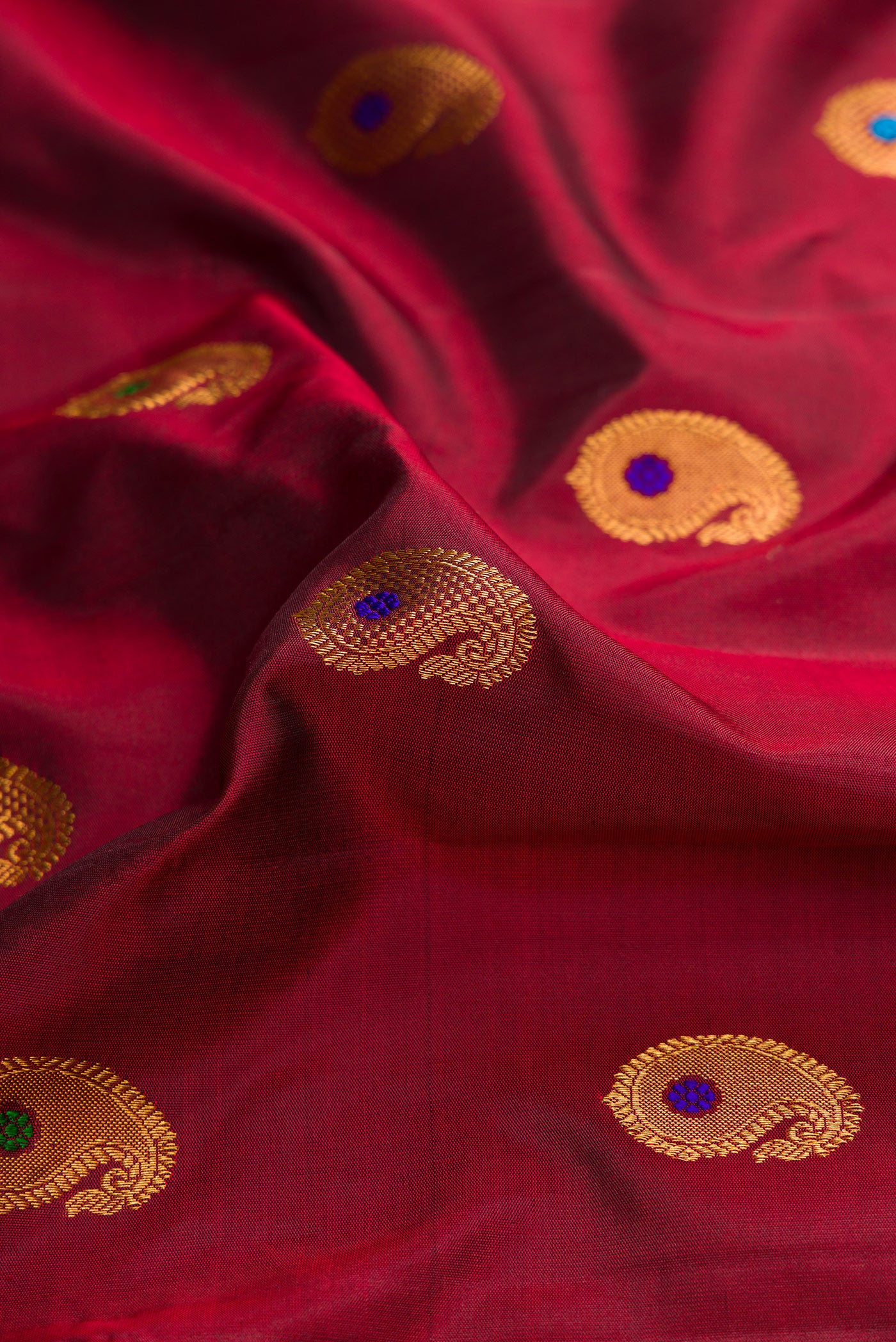 Close up of Maroon Dual Tone Gadwal Silk Saree with Zari And Thread Butta on the body and Zari Border.  displaying folds