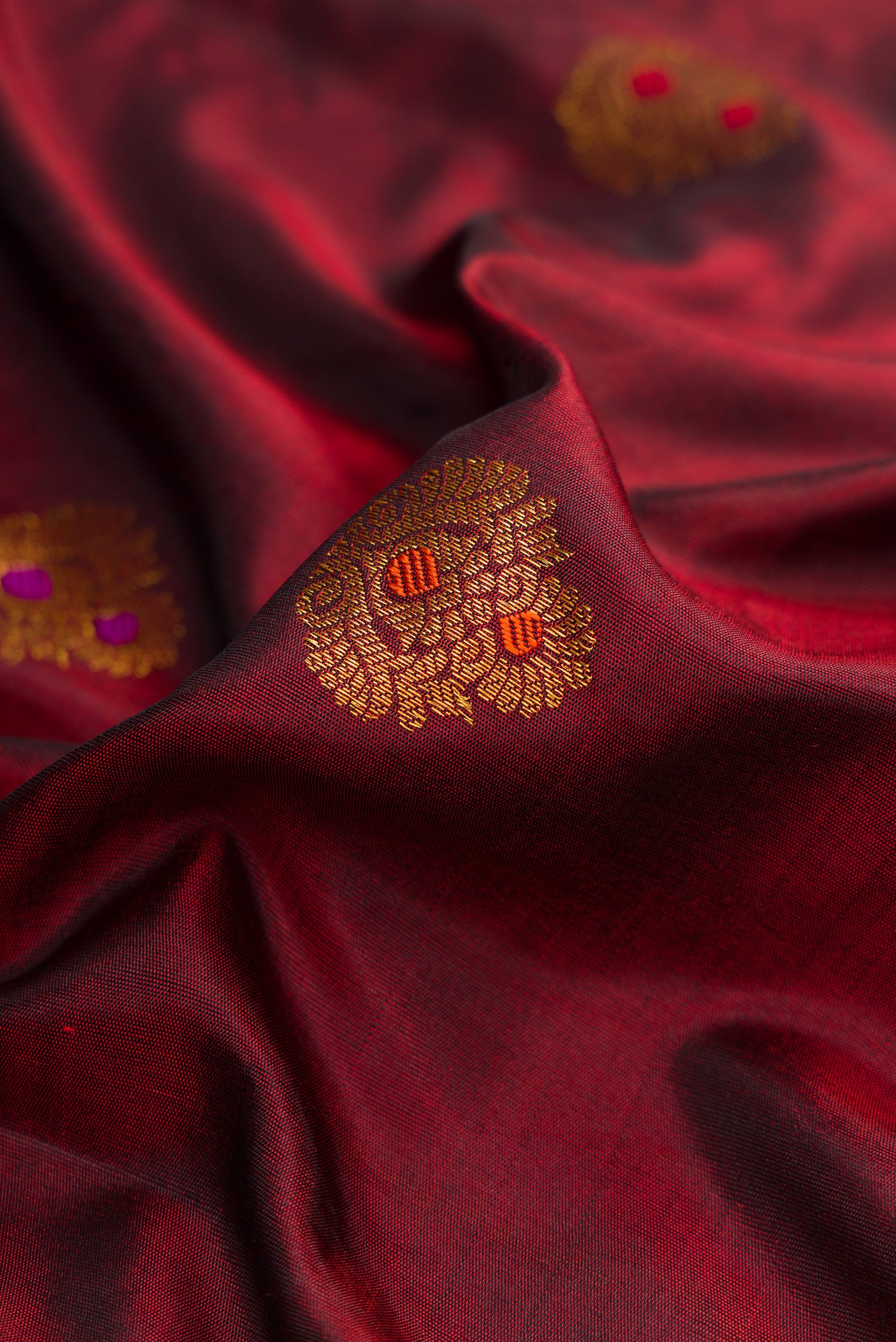 Close up of Maroon Dual Tone Gadwal Silk Saree with Zari Butta on the body and Zari And Thread Border.  displaying folds